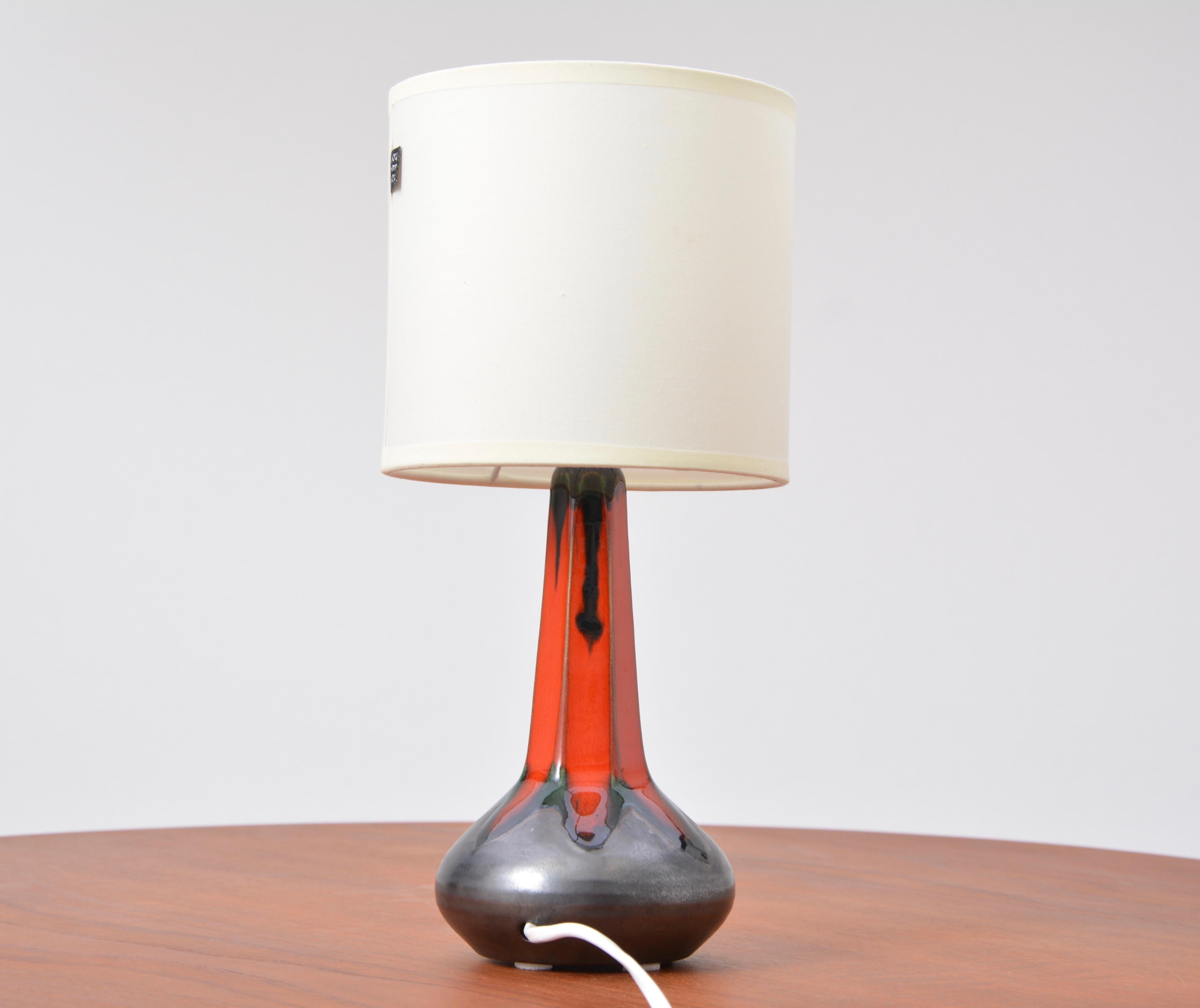 Danish Mid-Century Modern table lamp by Ole Christensen

This ceramic table lamp was designed in the 1960s and produced by Ole Christiansen in Denmark. The lamps base is black, the top has a beautiful red ceramic glaze. It has a new fabric shade,