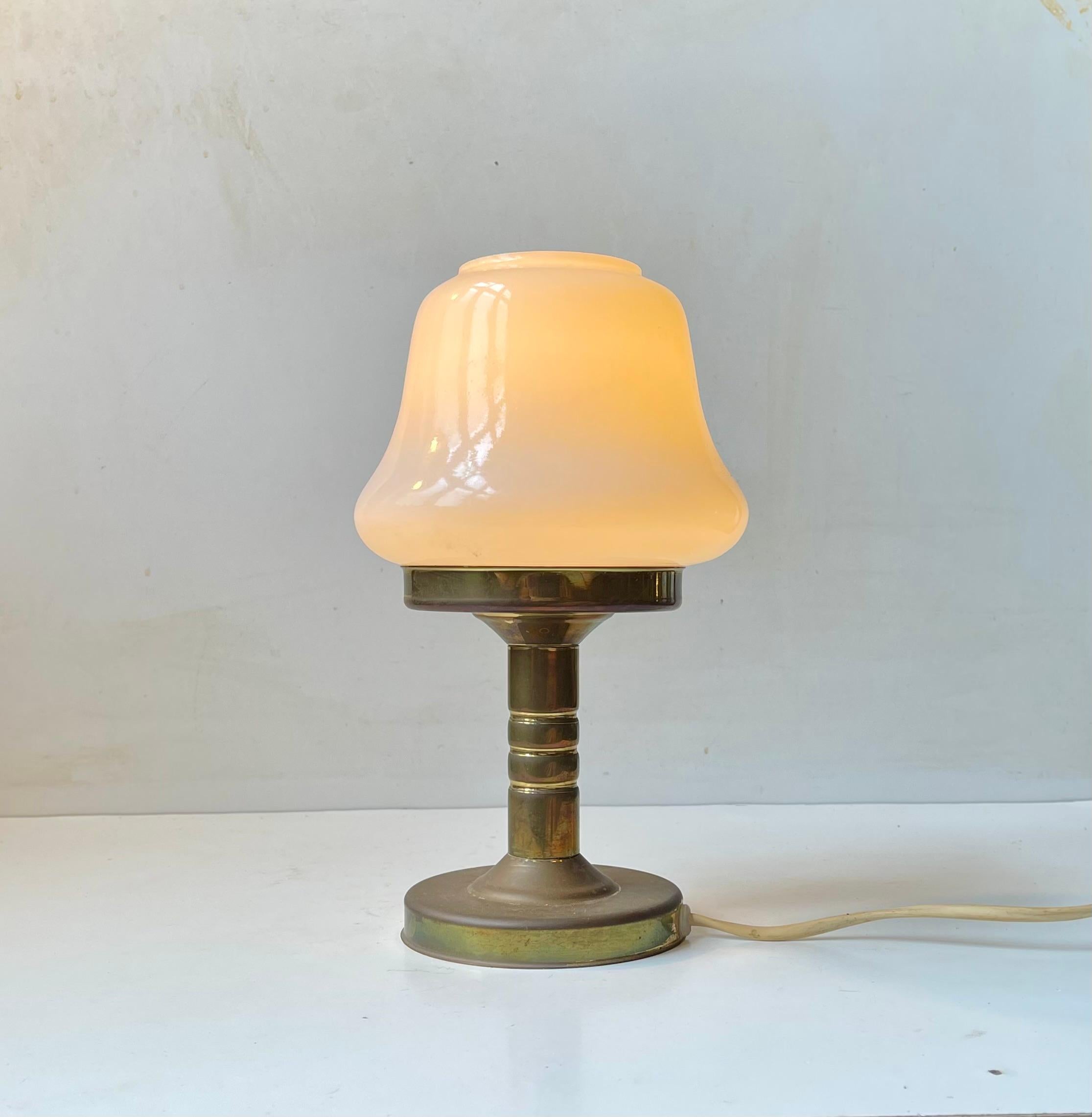 Pequeña lámpara de mesa de construcción simplista del danés ABO - Metal Art Studio - Randers. Con base de latón y pantalla de cristal opalino blanco en forma de campana. Fabricado y diseñado a principios de la década de 1970. El estilo de esta