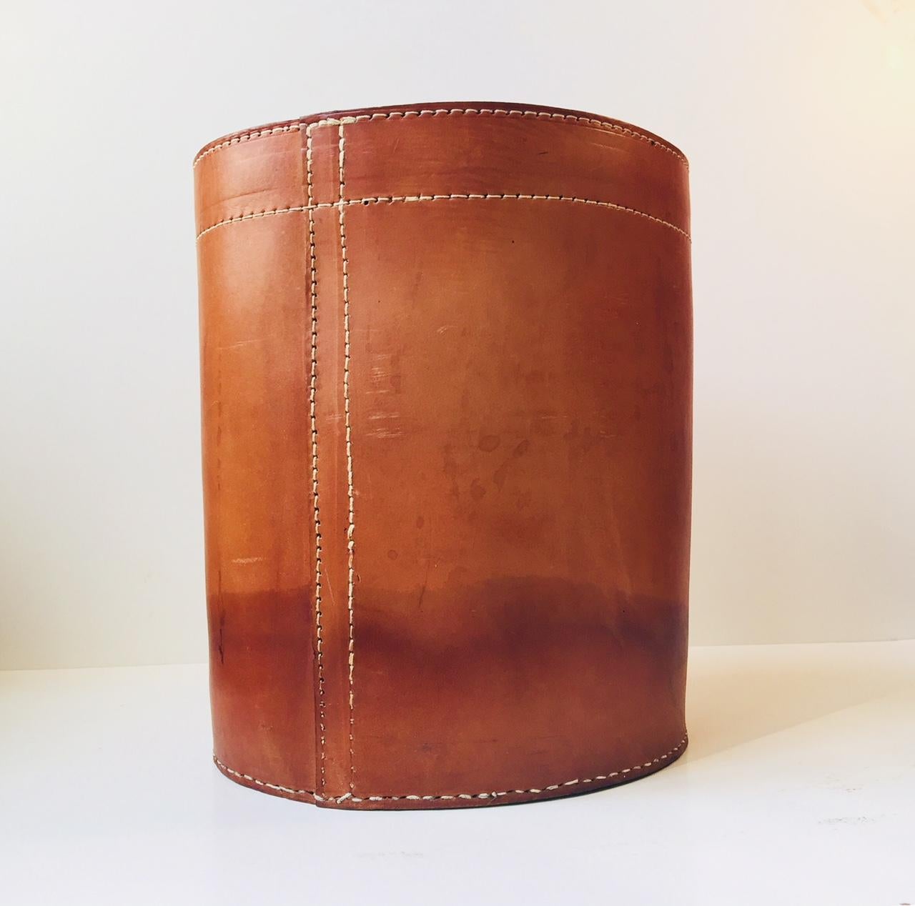 Naturally aged and patinated office waste basket in very thick leather (9mm). It was manufactured in Denmark during the 1960s in a style reminiscent of Jacques Adnet and Carl Auböck. It was probably commissioned by Illums Bolighus in Copenhagen,