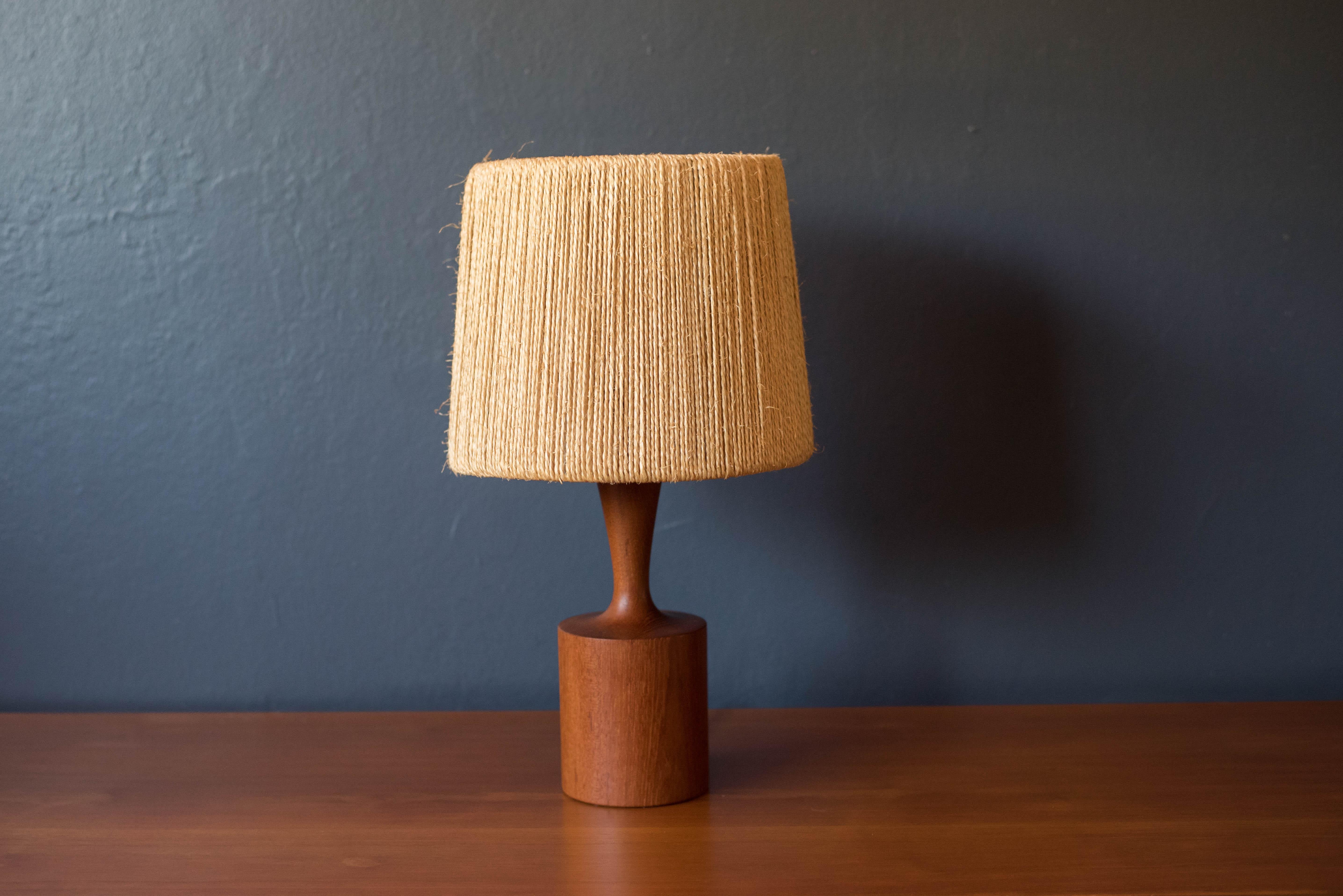 Mid-Century Modern accent table lamp by Fog and Morup, Denmark circa 1960s. This piece features a unique sculpted teak stem and base including the original natural jute drum shade. 


Base 4