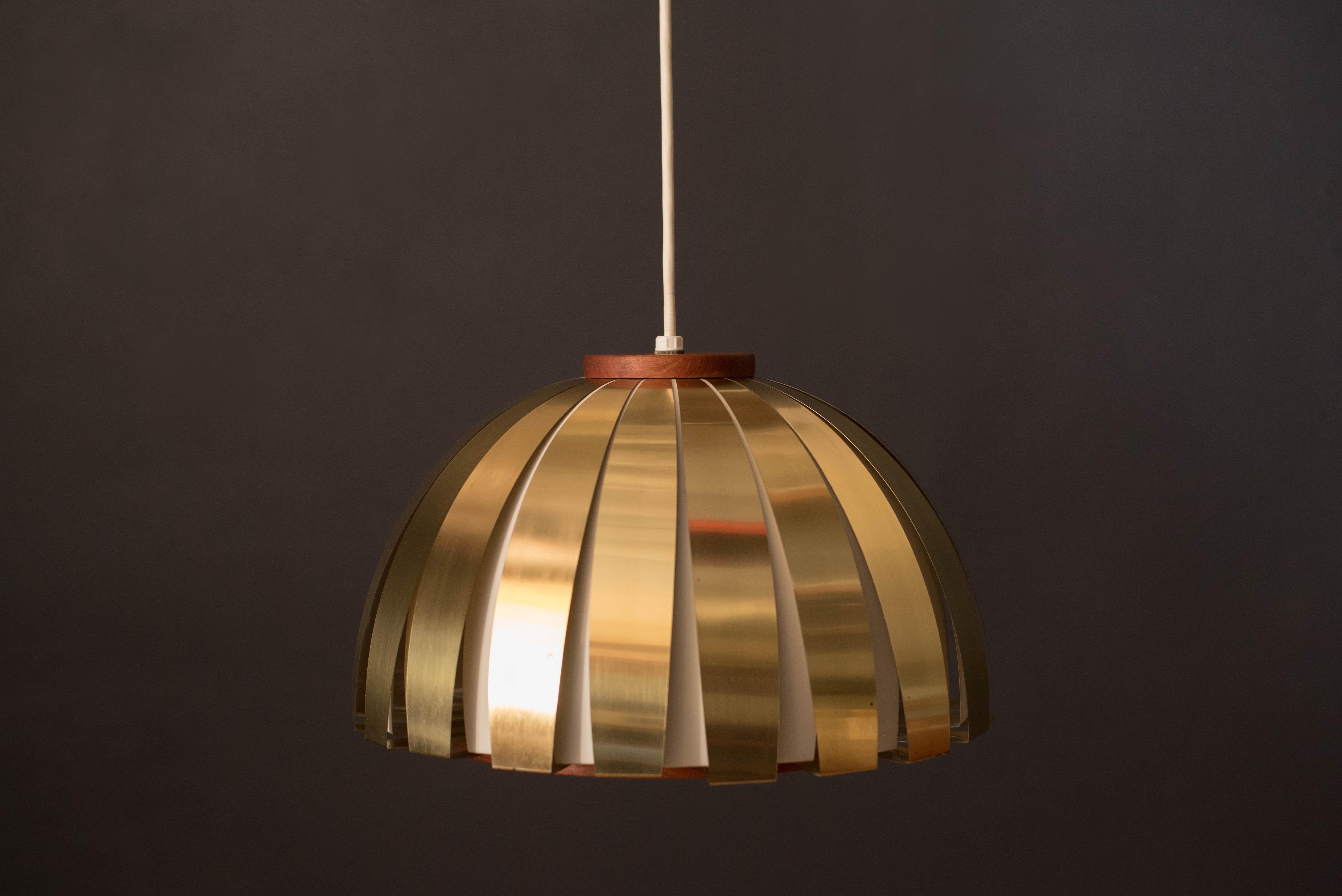 Mid Century Modern fiesta pendant lamp designed by Sven Aage Holm Sørensen for Holm Sørensen & Co., Denmark circa 1960's. This hanging light fixture features a rounded dome shape in brass and teak. The acrylic shade emits a warm glow that