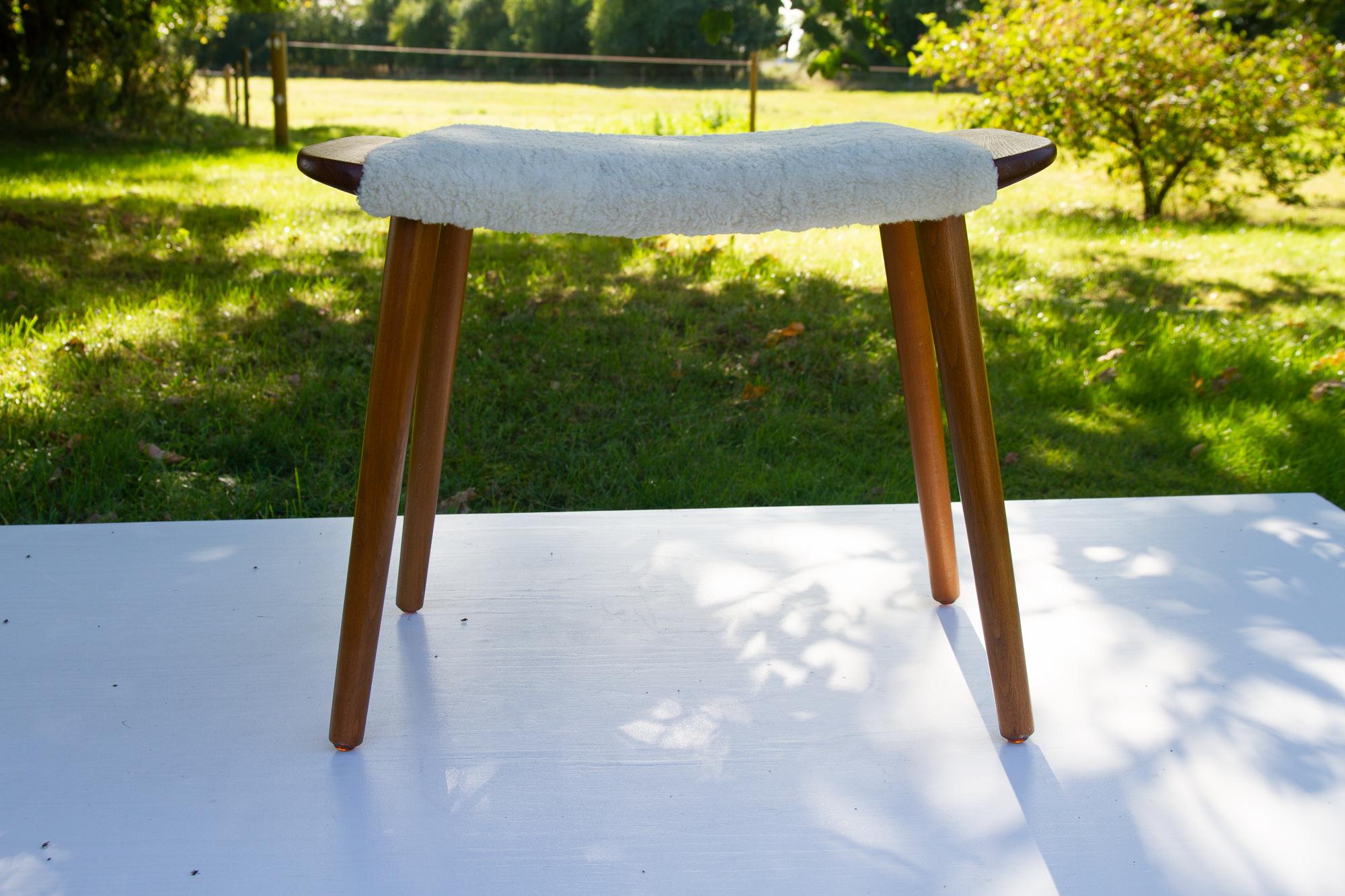 Vintage Danish Teak and Lambskin stool, 1960s
Elegant footrest with curved lambskin covered seat, handles in teak and round tapered legs in beech. Manufactured in Denmark in the 1960s.
Legs can be removed for transport.
Very good original