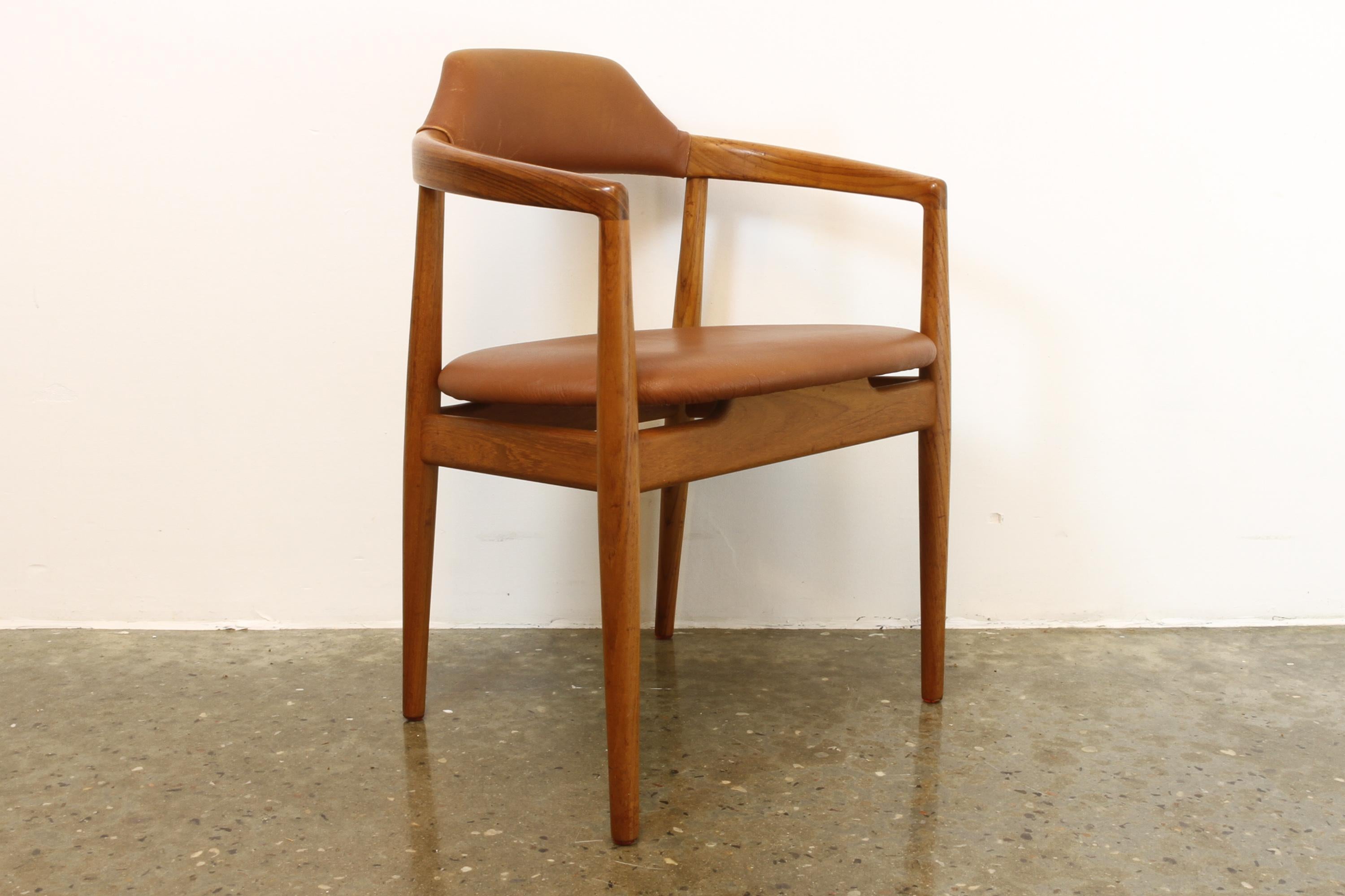 Vintage Danish teak and leather armchair, 1960s.
Elegant and stylish Scandinavian Mid-Century Modern armchair in solid teak with cognac colored leather upholstery. Large curved backrest and armrests. Round tapered legs. Beautiful joinery and