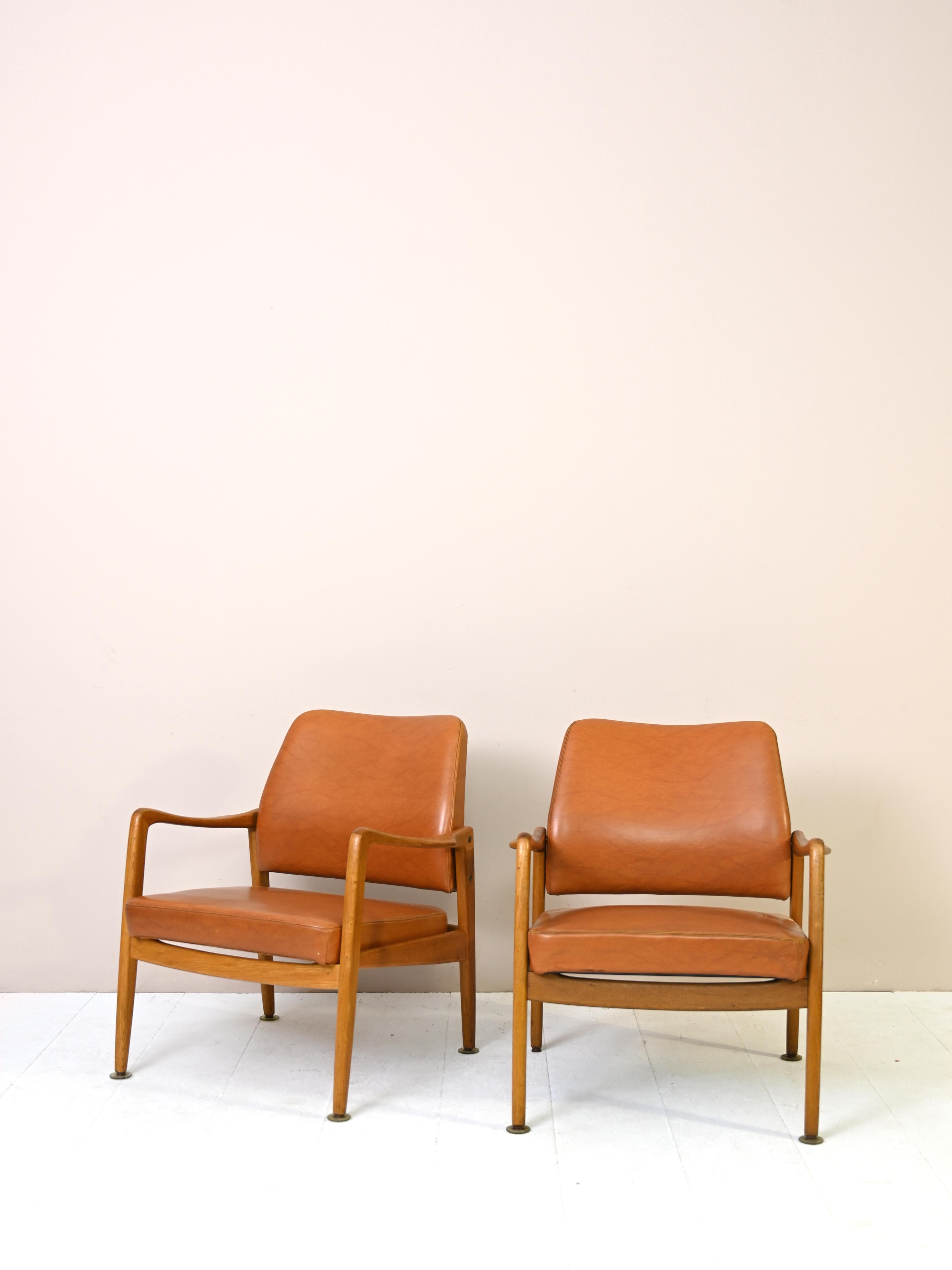 Pair of original Scandinavian armchairs from the 1950s made of teak wood and cognac-colored leather.

These comfortable and timelessly beautiful seats can be placed in a living room or bedroom and will give the room a Nordic and elegant