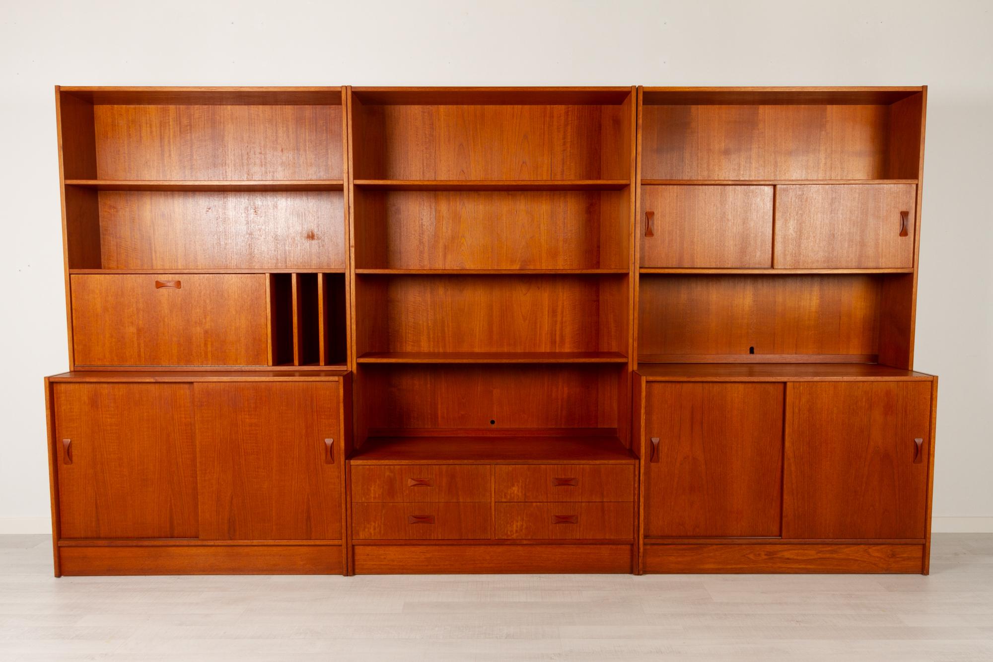 Vintage Danish teak bookcase by Clausen & Søn Silkeborg, 1960s
Large modular bookcase in three sections, each with top and bottom module. Iconic bow tie style pulls on drawers and sliding doors. Contains two large cabinets with sliding doors,