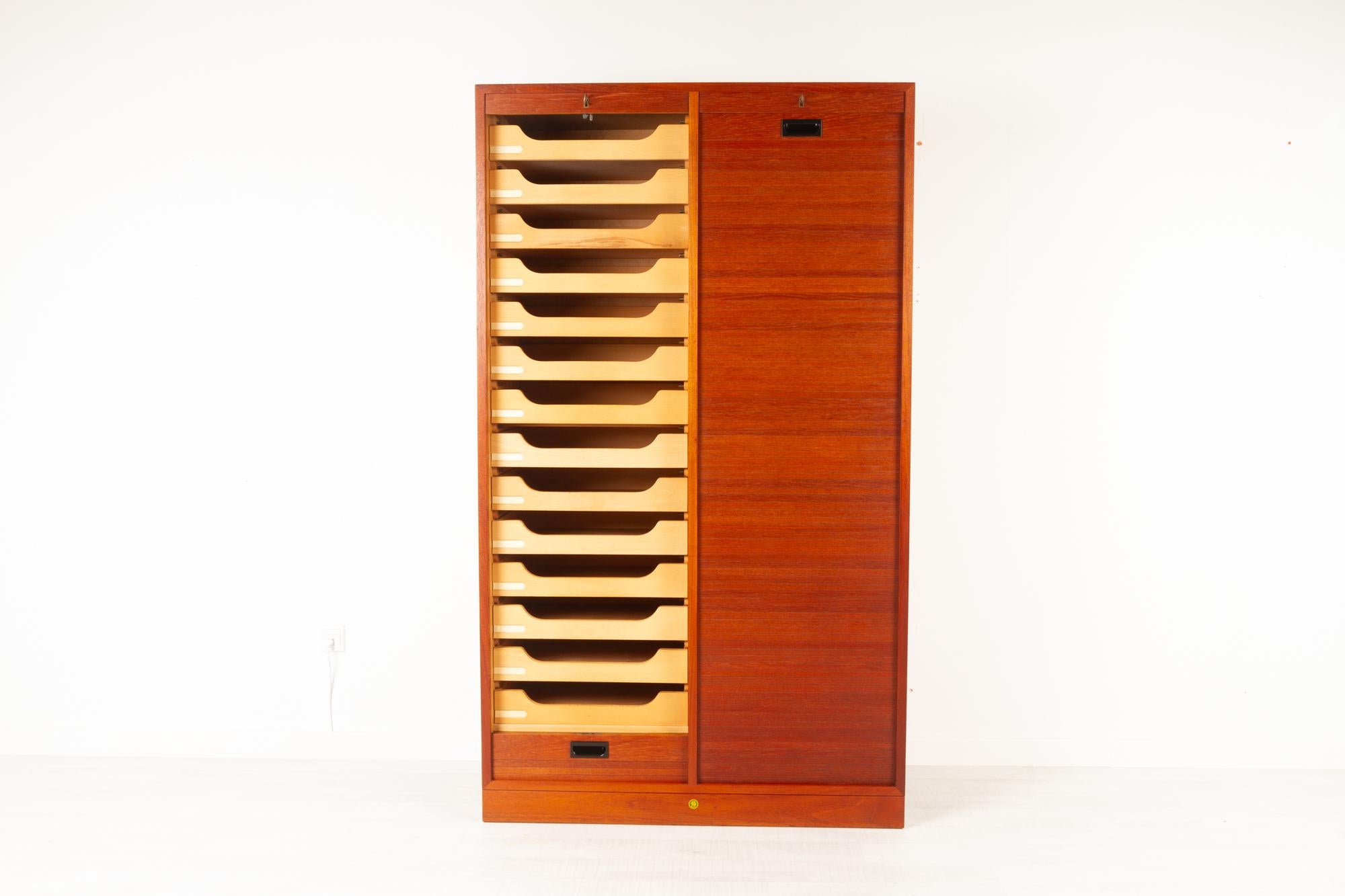 Vintage Danish teak cabinet with tambour doors, 1960s
Danish modern large double filing cabinet with vertical sliding tambour front in teak made by Bjerringbro Savværk in Denmark. Two separate compartments, one with 14 drawers and one with three