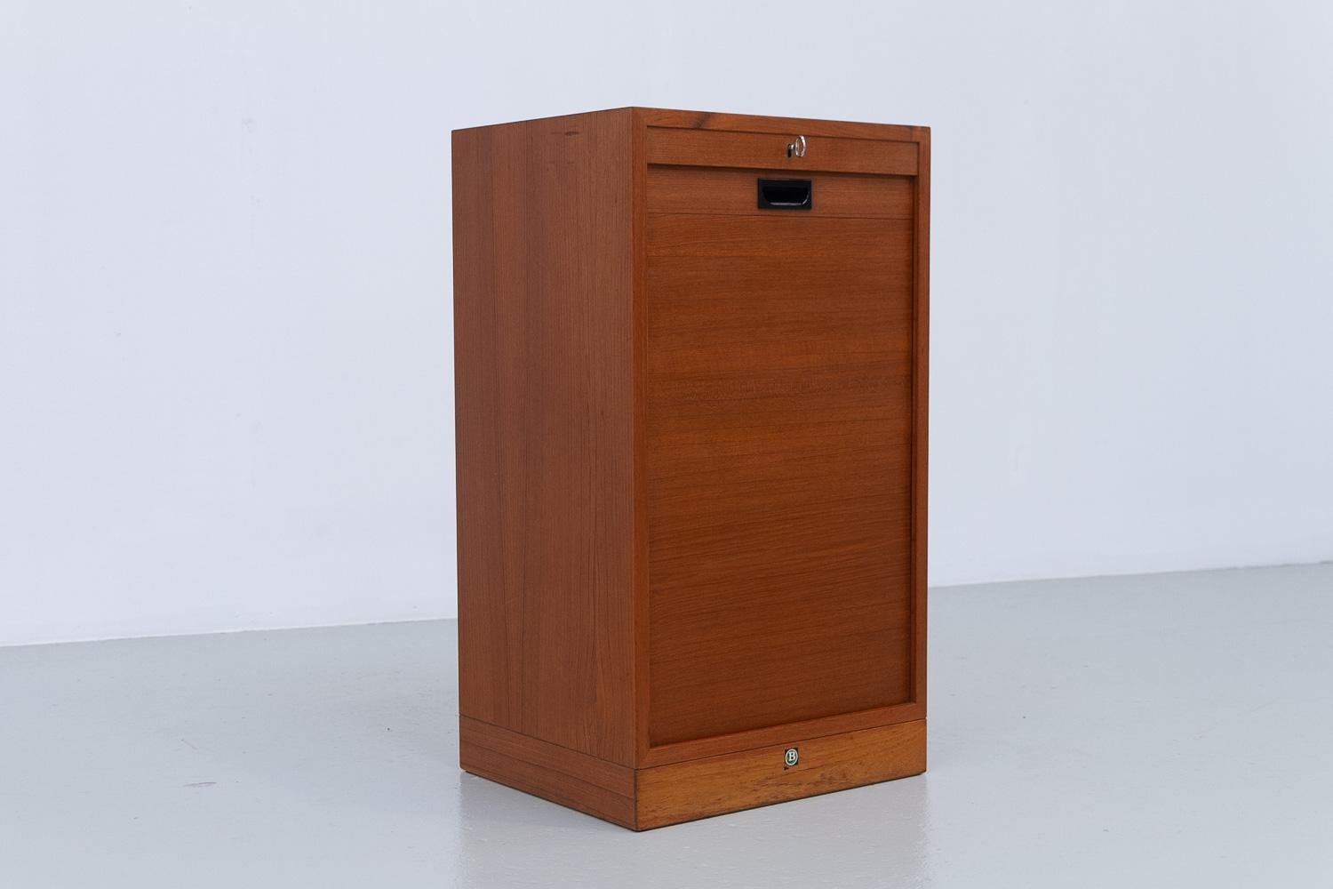 Dänischer Vintage-Schrank aus Teakholz mit Tambourfront, 1960er Jahre.

Kleiner Vintage-Schrank aus dänischem Teakholz mit Rolltür von Bjerringbro Møbelfabrik, Dänemark 1960er Jahre.
Moderner dänischer Archivschrank mit vertikaler Schiebetür aus