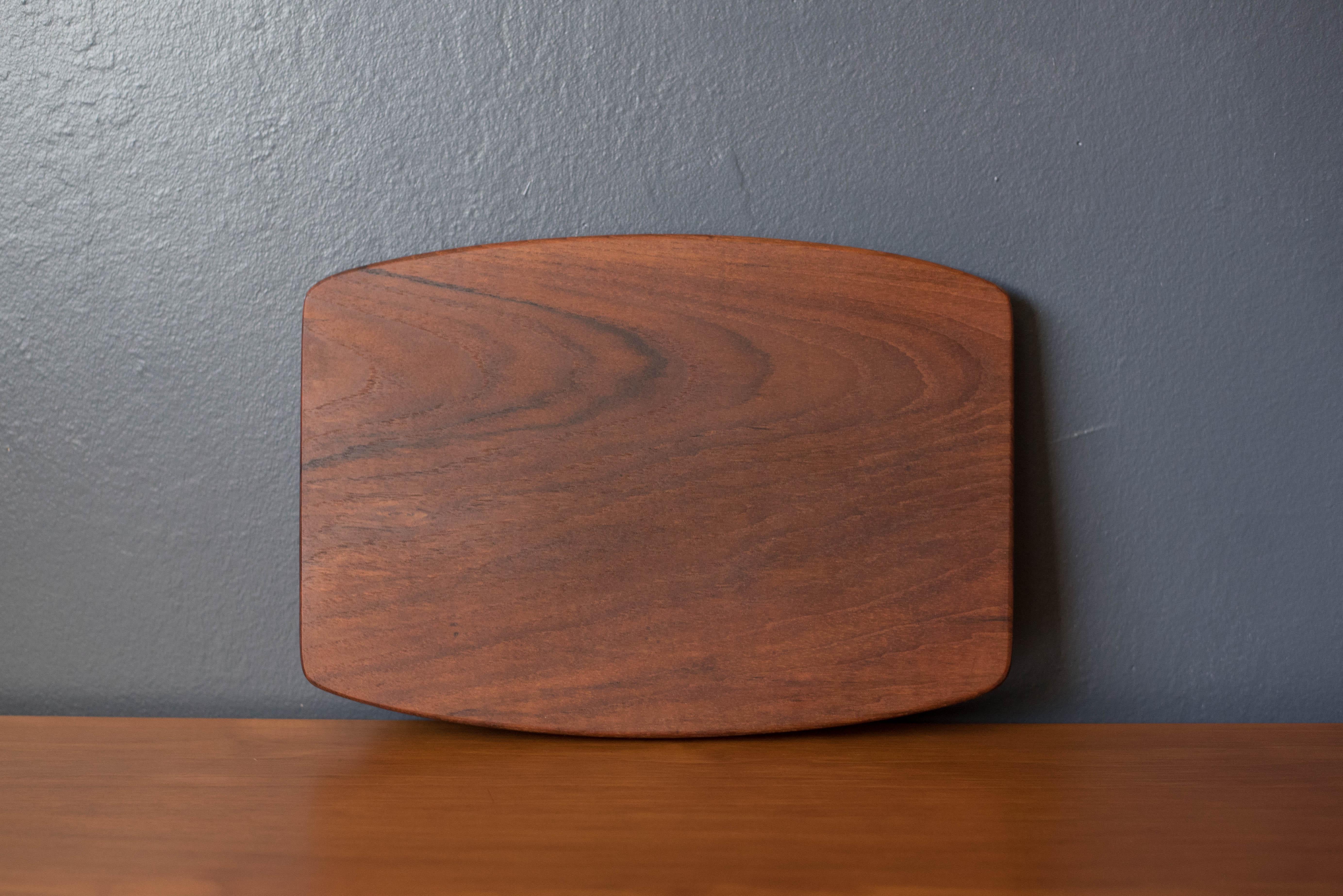 Mid-Century Modern serving tray platter manufactured by Wiggers, Denmark. Unlike most Danish trays, this was constructed of one solid piece of teak with clever cutout handles underneath. Perfect to display for your home decor collection or as a