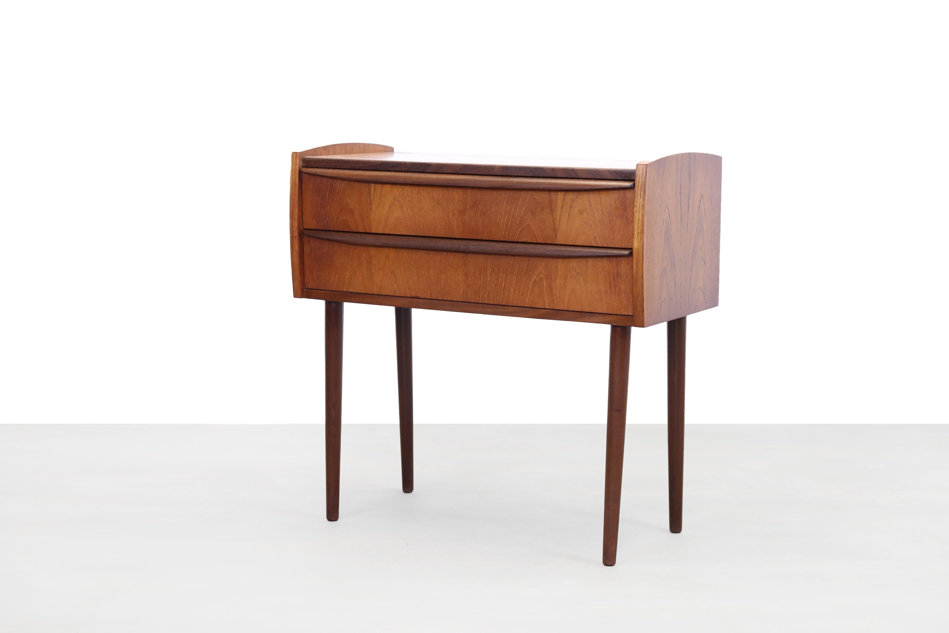 Danish design chest of drawers with 2 drawers. Made of teak. The design of the cabinet is typically Mid-Century Modern, straight and without fuss, with beautiful round details in the edges and the handles of the drawers. Nice size that you can put