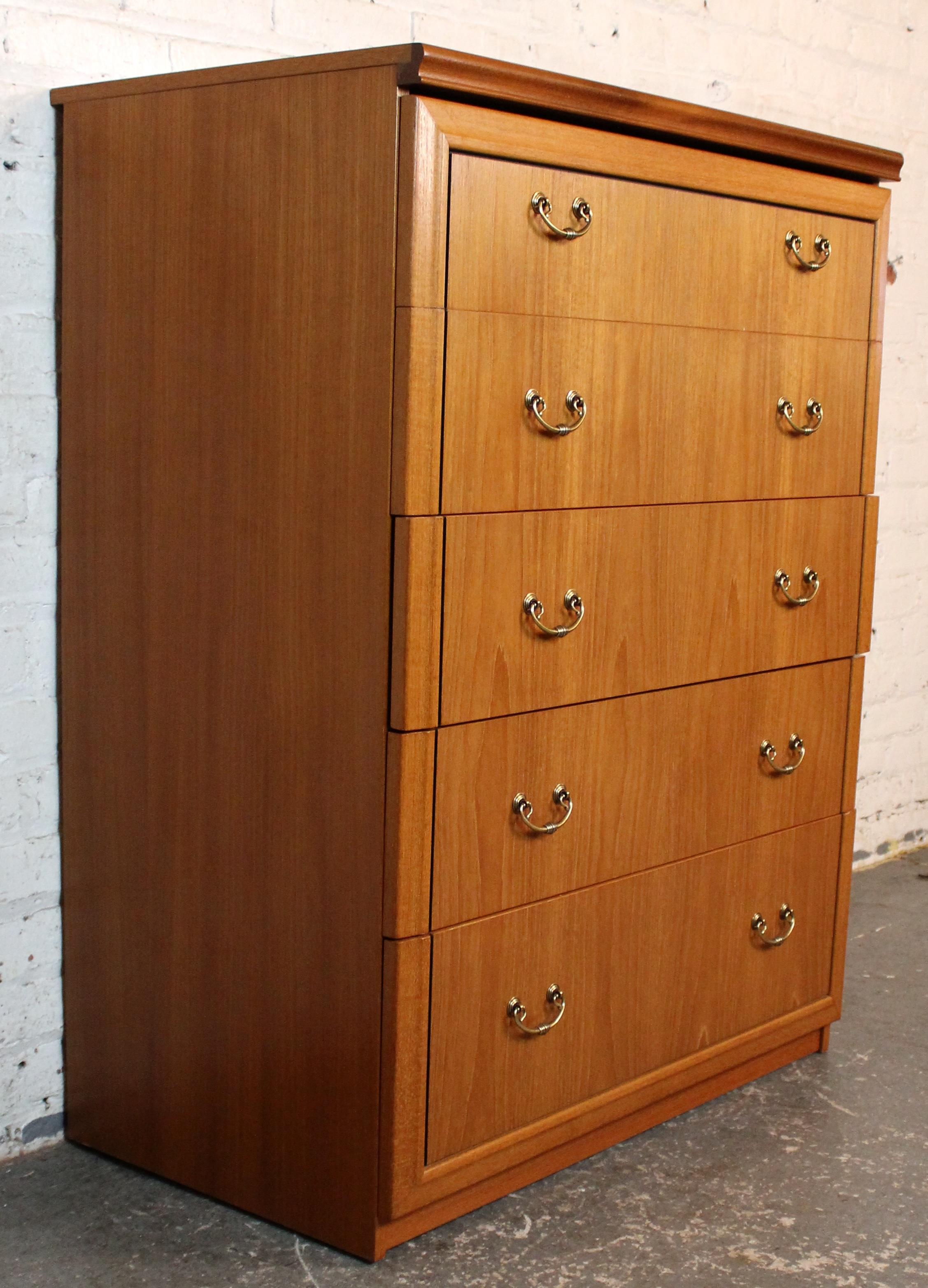Elegant mid-century Danish teak chest featuring clean lines, rich wood grain, and classic brass hardware. This five-drawer design offers generous storage while maintaining a sleek, minimalist silhouette. Perfect for adding timeless Scandinavian