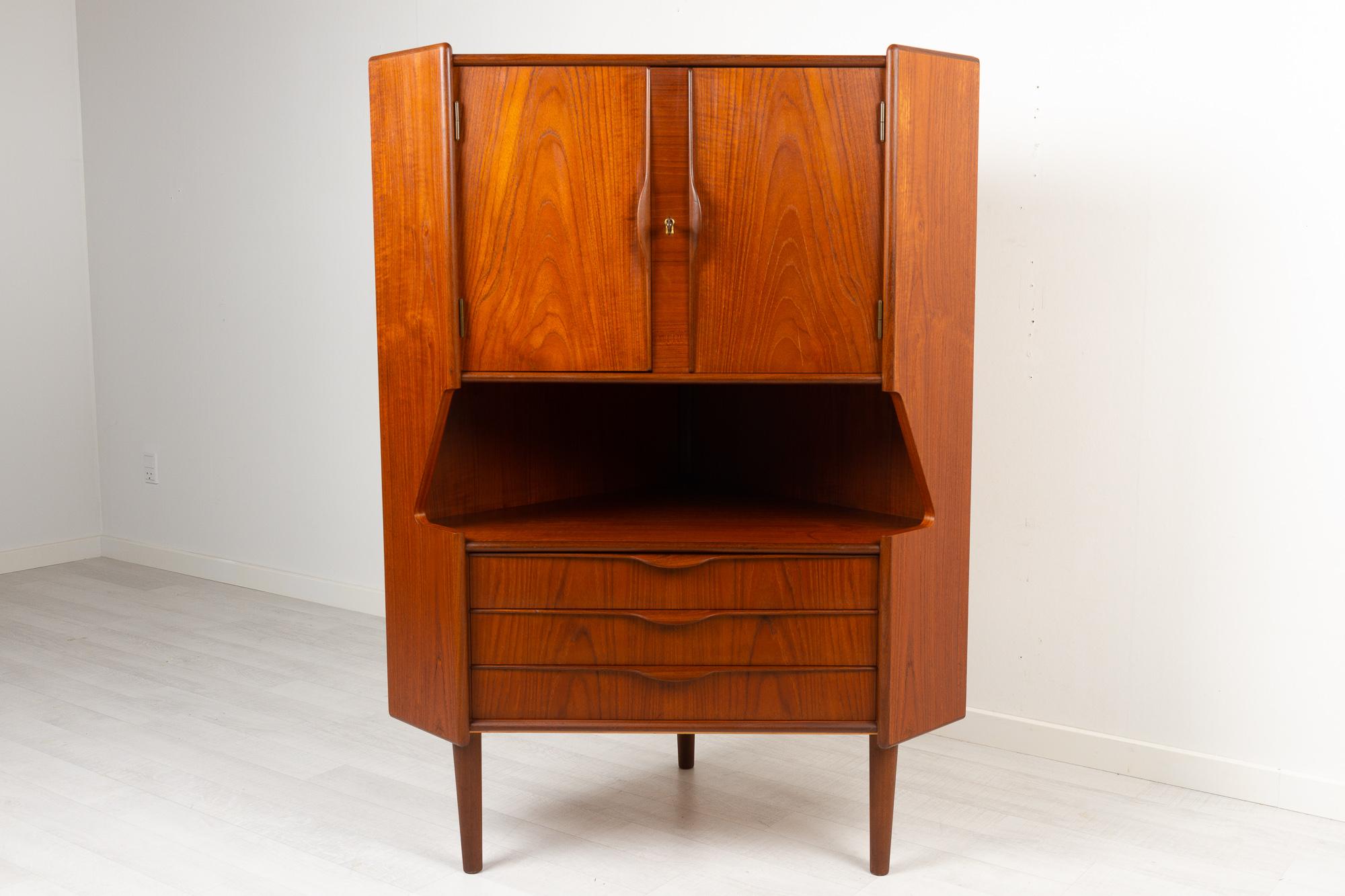 Vintage Danish teak corner cabinet with dry bar, 1960s
Danish Mid-Century Modern corner cabinet with bar unit and drawers. Cabinet behind double doors with lock and key. Inside decorated mirror and curved shelf. Amble space for glasses and bottles.