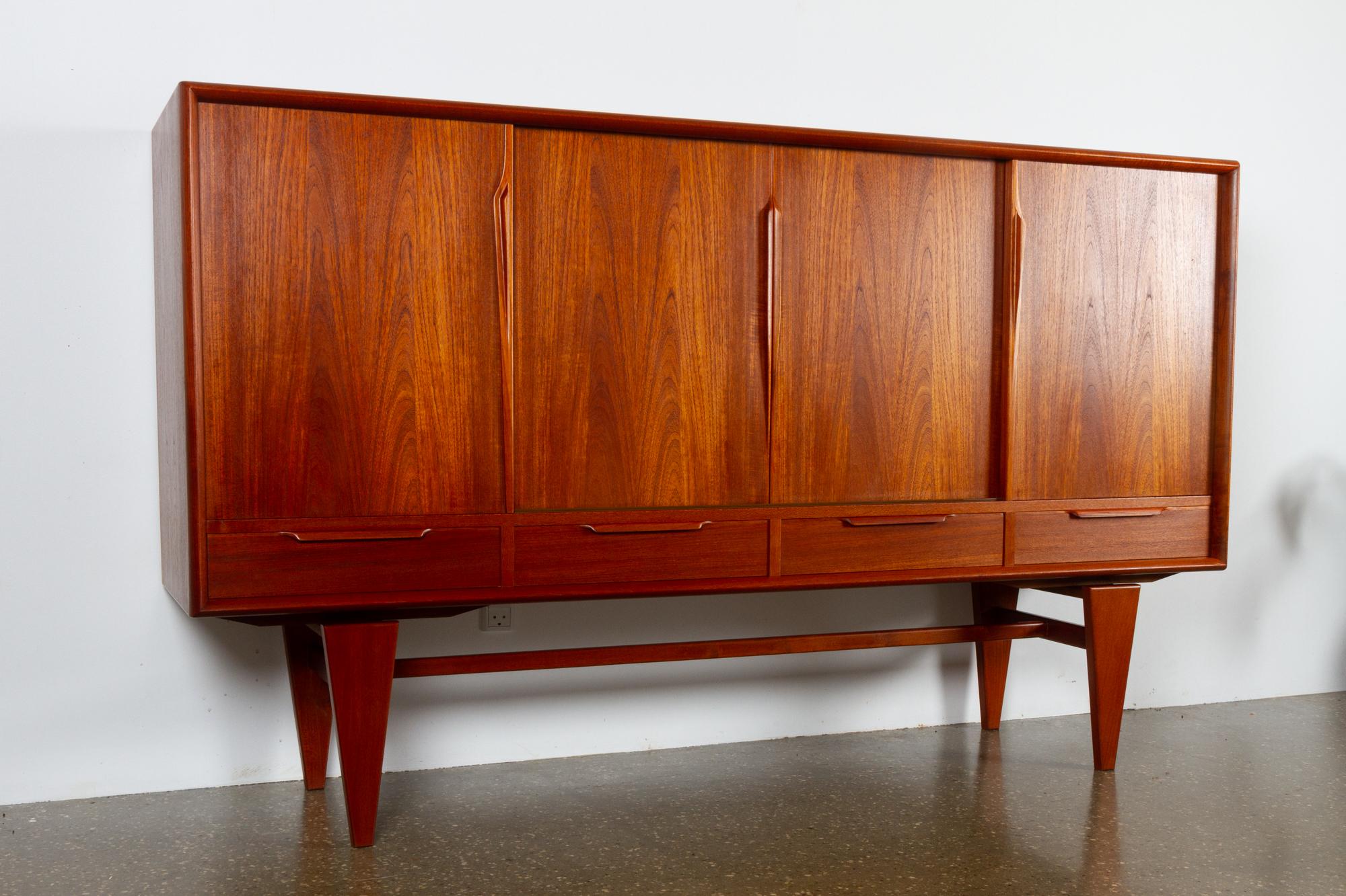 Vintage Danish teak credenza by ACO 1960s.
Very high quality highboard by Axel Christensen, Odder, Denmark. Spacious and elegantly proportioned sideboard with four sliding doors and four outside drawers. Loads of storage space with easy access.