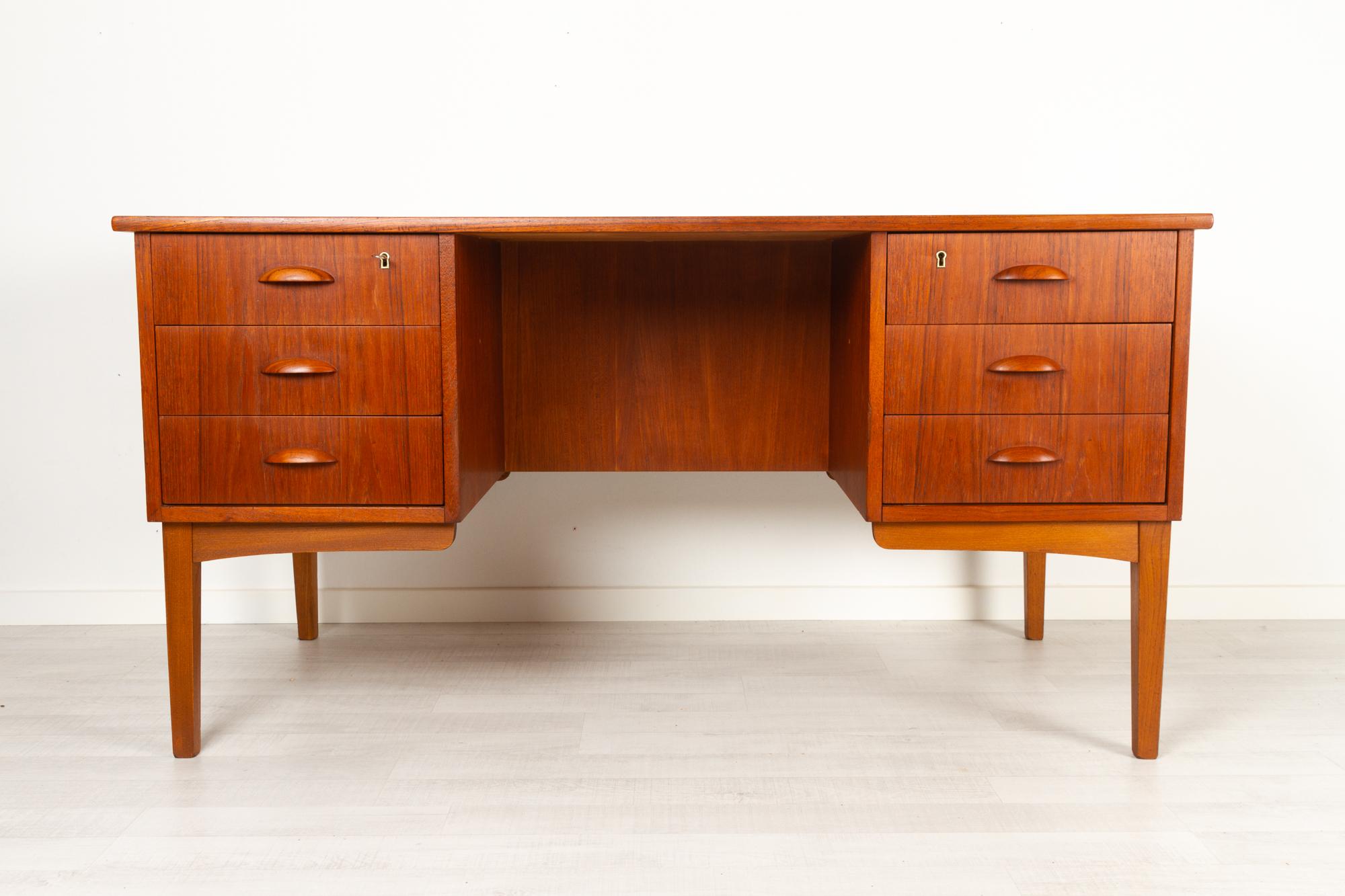 Vintage Danish teak desk 1960s
Elegant and Classic Danish Mid-Century Modern freestanding writing desk in teak with oak legs. Front with six drawers, two with lock. Halfmoon shaped drawer pulls in solid teak. Backside with open height adjustable