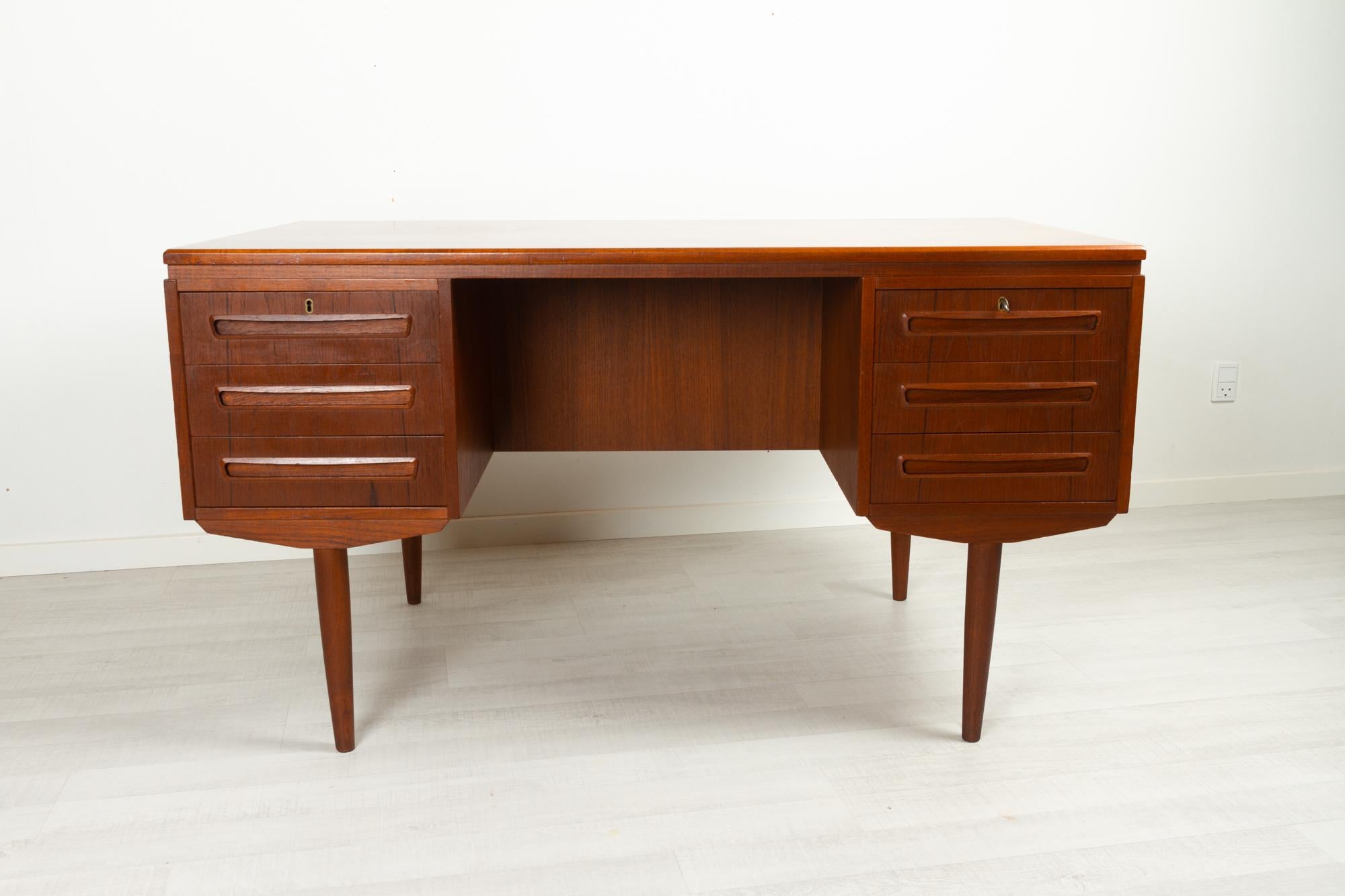 Vintage Danish teak desk 1960s
Danish Mid-Century Modern freestanding teak writing desk. Model 26 made by Andreas Pedersens Møbelfabrik in Svenstrup (AP Møbler) 
Front with two drawer compartments with three drawers each. Top drawers with lock.
