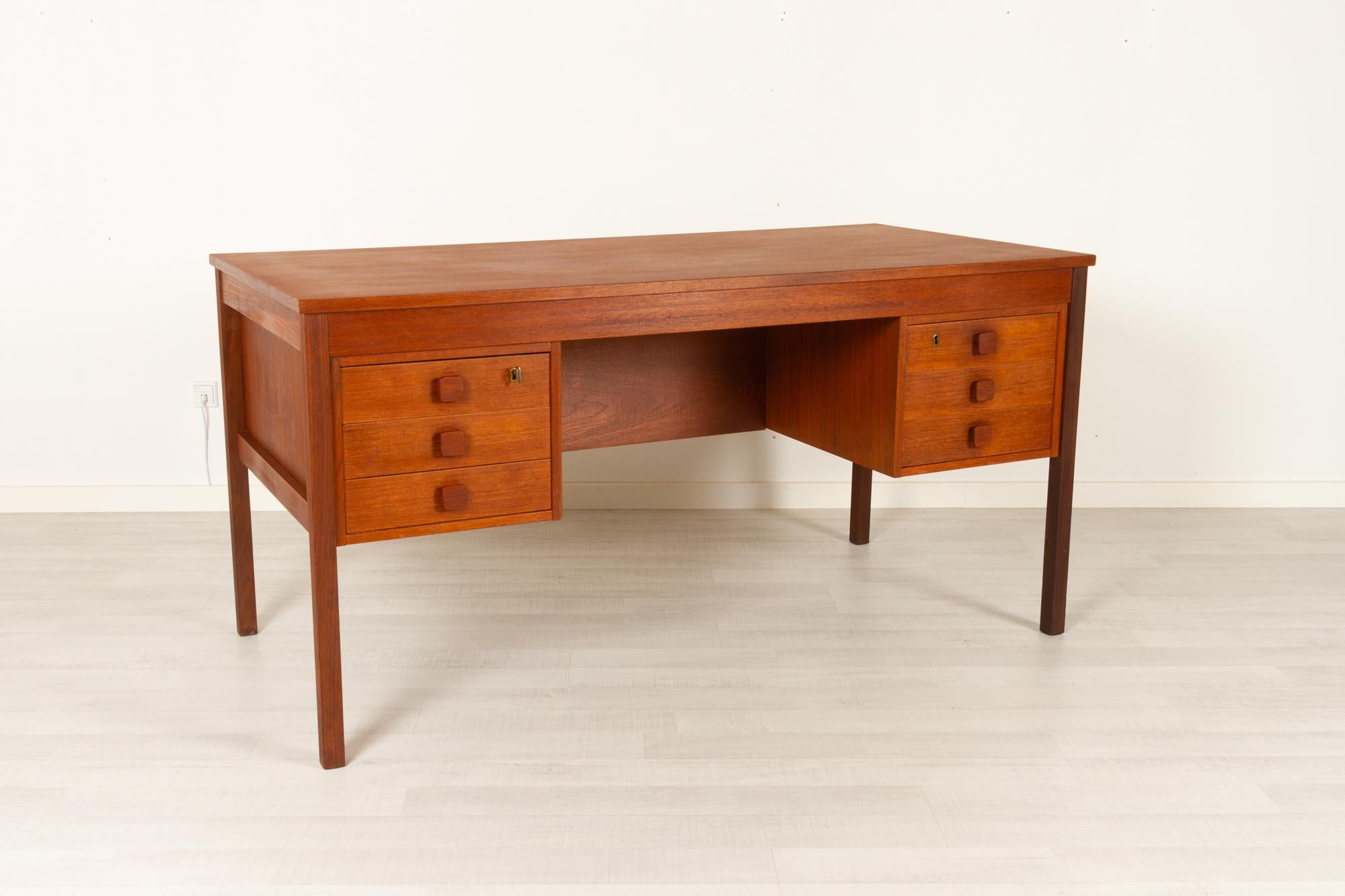 Vintage Danish teak desk by Domino Møbler 1960s
Classic Scandinavian modern freestanding writing desk in teak. Beautiful top with expressive teak grain. Front with six drawers with dovetail joints, two with lock. Square drawer pulls in solid teak.