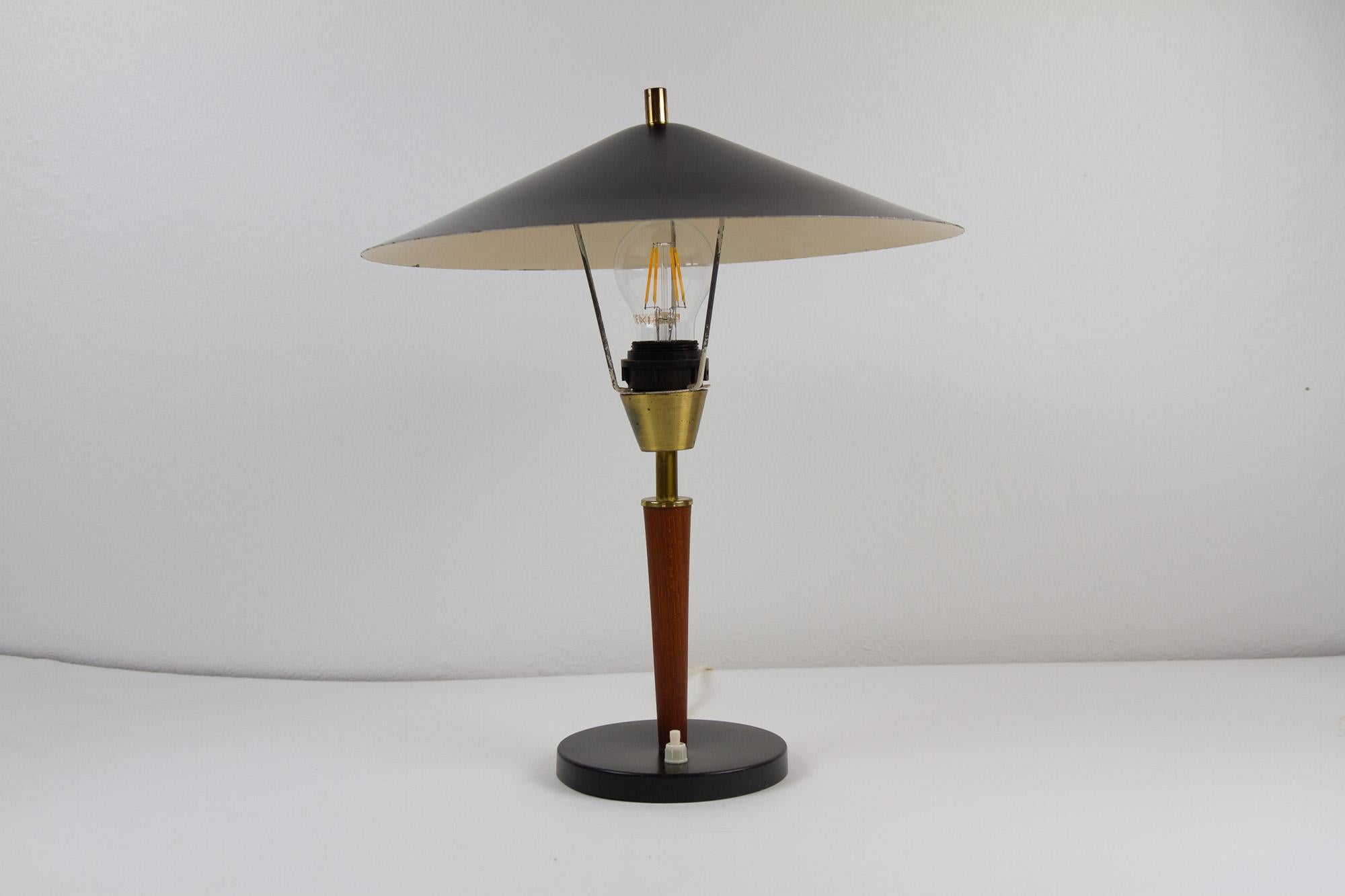 Vintage Danish Teak Schreibtischlampe, 1960er Jahre.
Dänische moderne Tischlampe mit Messingdetails. Schwarzer Sockel und schwarzer runder Schirm aus Metall. Vorbau aus massivem Teakholz. Swith an der Basis. Sehr gut geeignet als