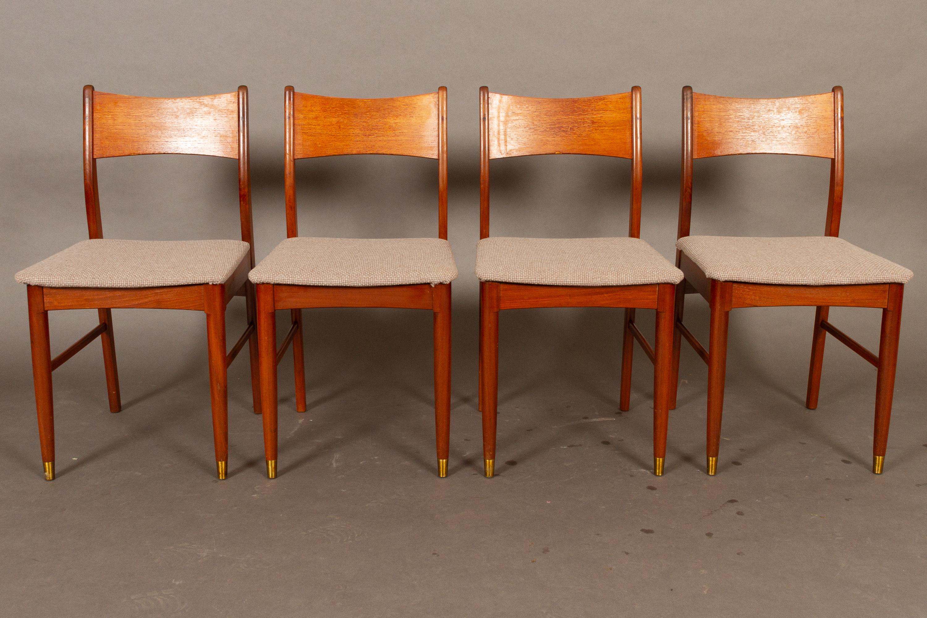 Vintage Danish teak dining chairs 1950s set of 4
Set of four elegant Danish Mid-Century Modern dining chair with solid teak frame and backrests in teak veneer. Legs are rounded and front legs have round brass shoes. Seats are upholstered with grey