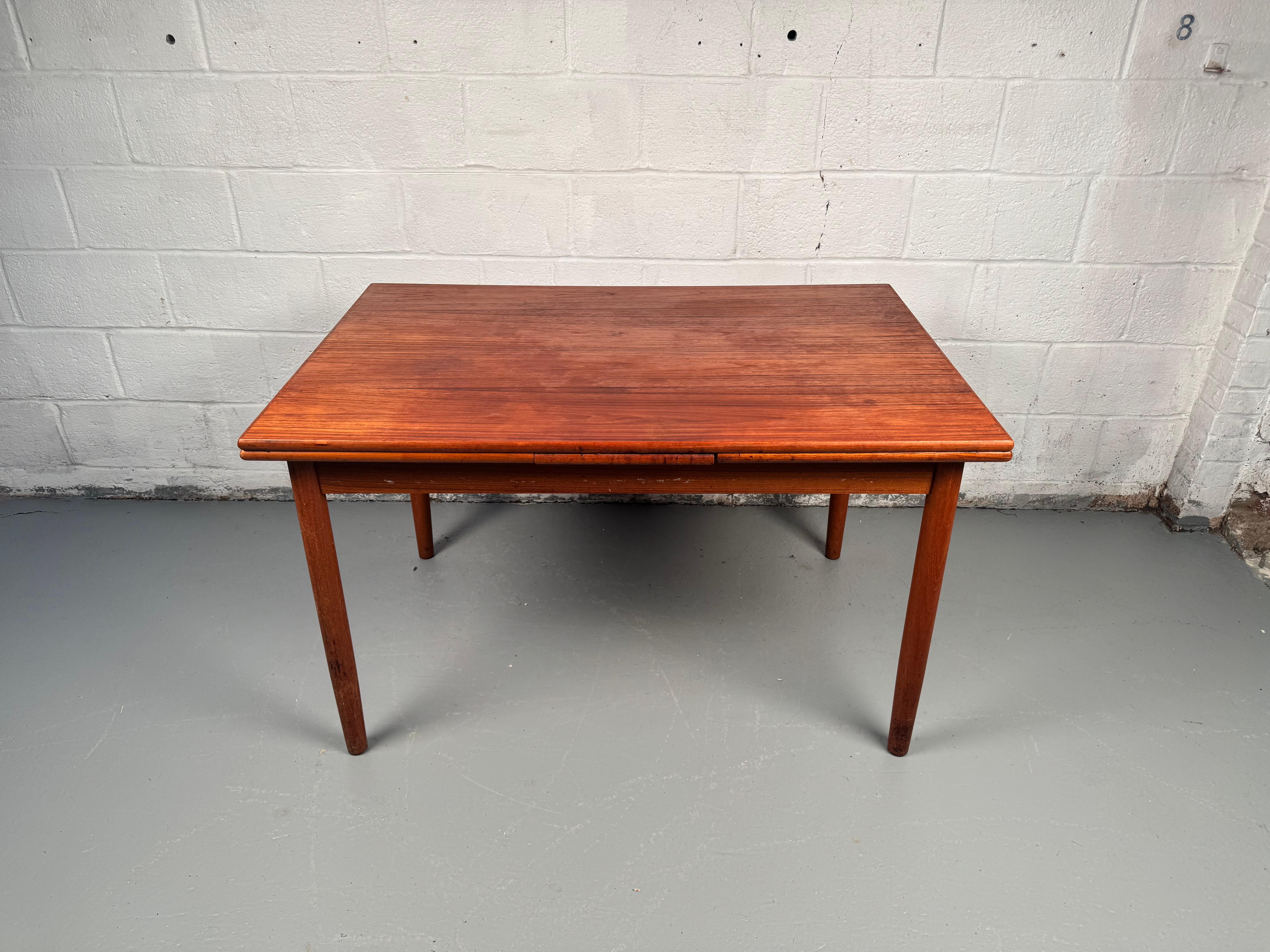 Timeless, functional, and beautifully crafted—this Vintage Danish Teak Draw-Leaf Dining Table is a quintessential piece of mid-century design. Made in Denmark from richly grained solid teak, it features sleek, minimalist lines and warm wood tones