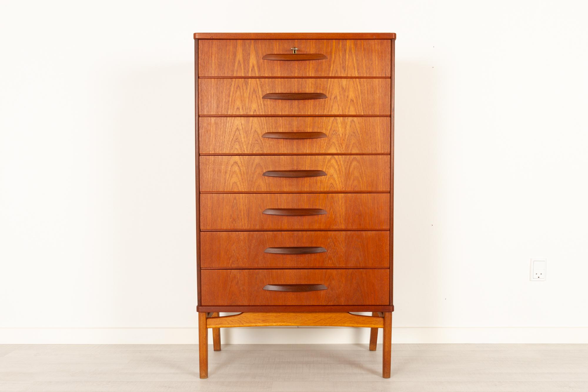 Vintage Danish teak dresser, 1950s
Tall and slender chest of drawers in teak. Rare model with seven drawers, each drawer with a single wide pull in solid teak. Frame in oak with round tapered legs. Top drawer has a lock and comes with one key.
The