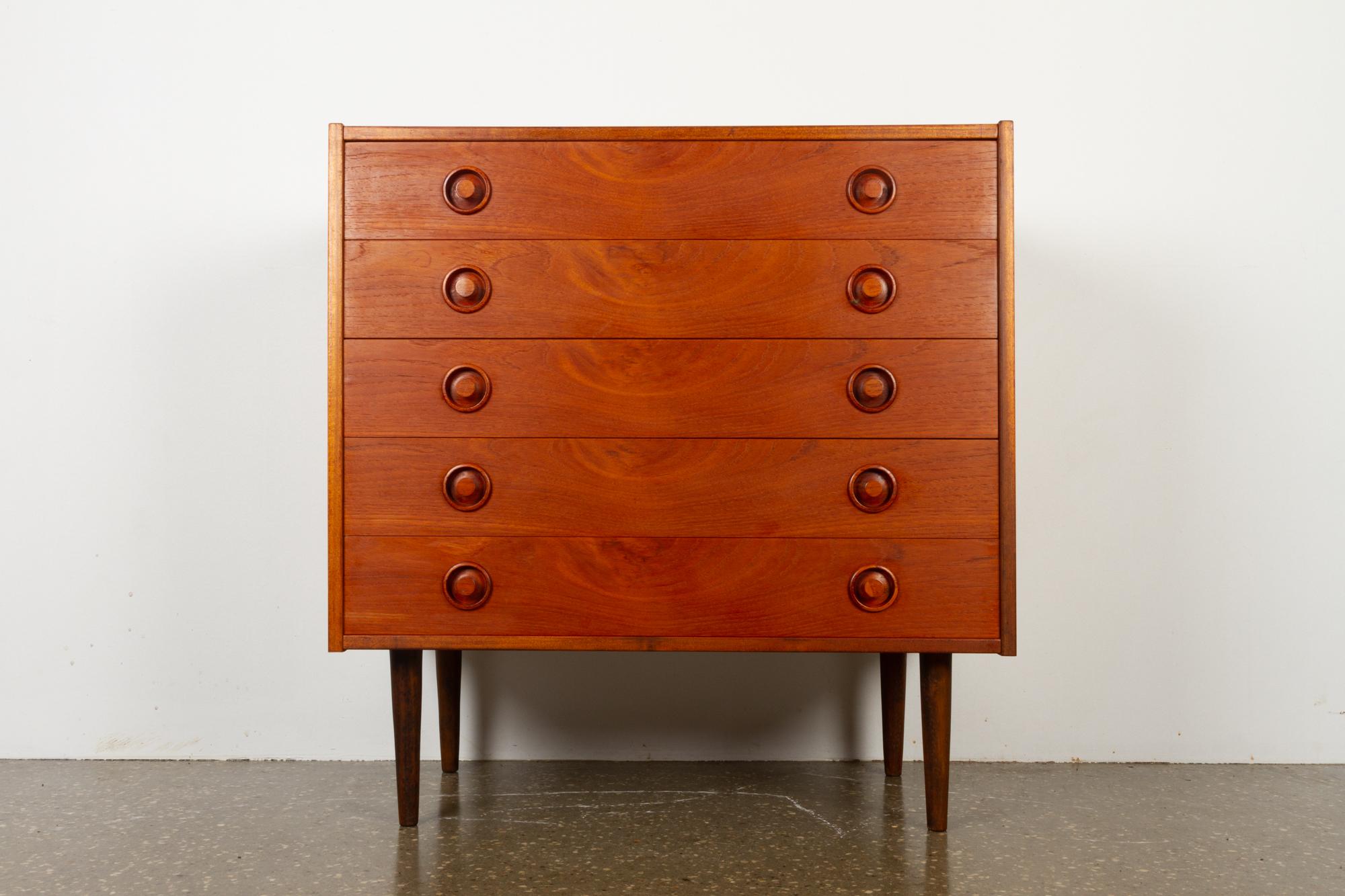 Vintage Danish teak dresser, 1960s
Elegant Mid-Century Modern chest of drawers with lovely round grips in solid teak.
Five wide drawers offers loads of storage space. Standing on four round tapered legs.
Beautiful veneer color and grain with a
