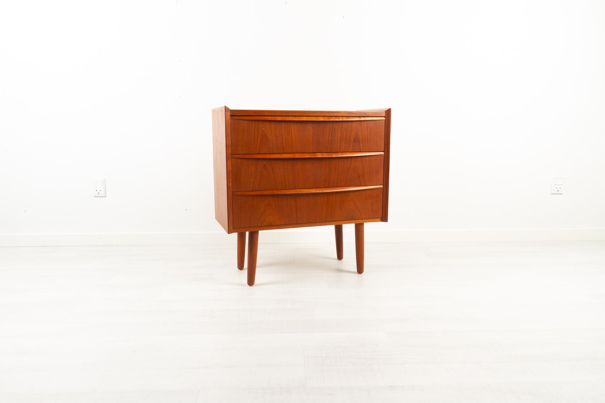 Vintage Danish teak dresser 1960s
Elegant Danish Mid-Century Modern chest of drawers. Three wide drawers with full length organic shaped pulls in solid teak. Frame with bevelled edged. Standing on four round tapered legs. Very beautiful and warm