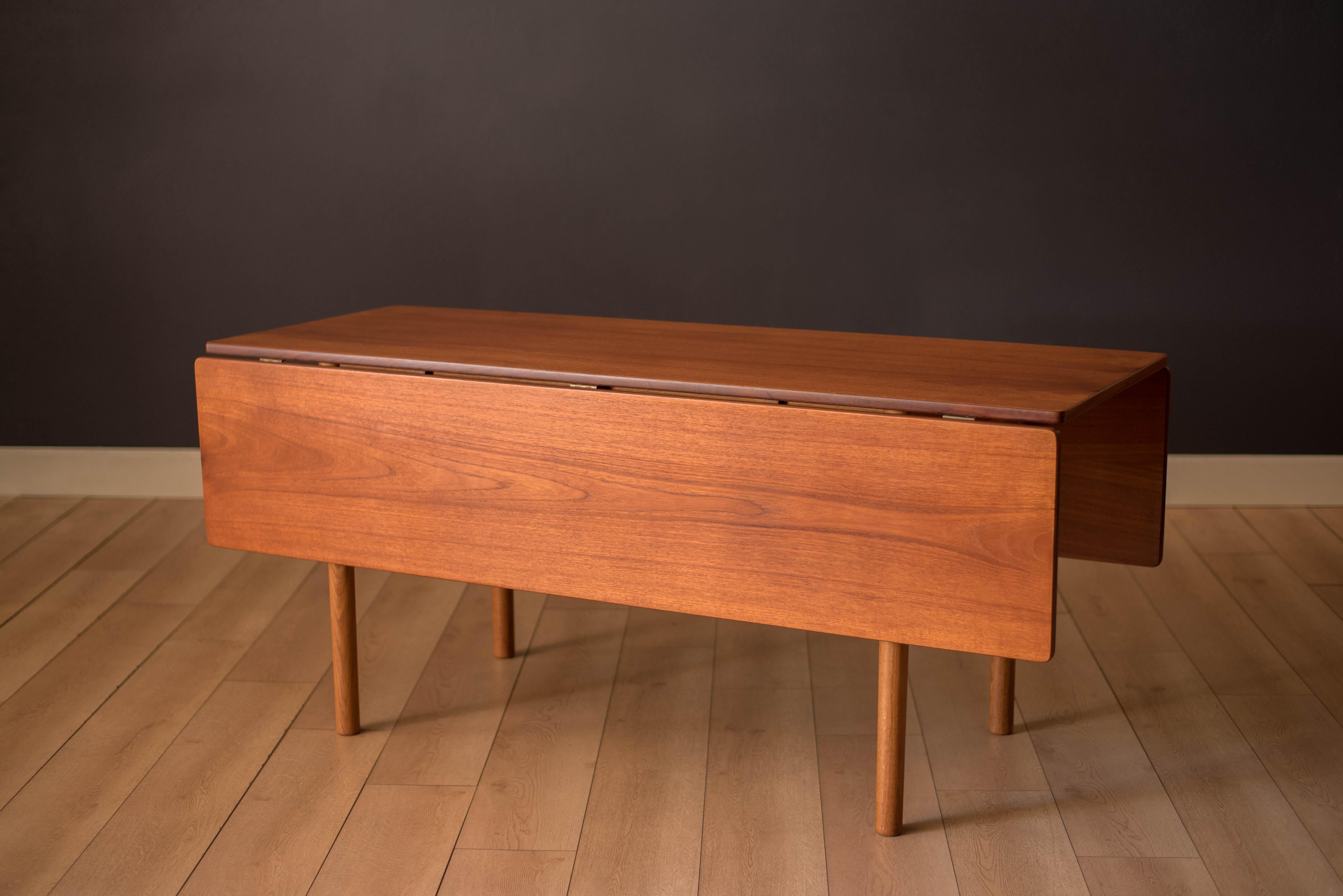Vintage expandable console dining table in teak and oak designed by Børge Mogensen, Denmark. This clever design is accented with brass hardware including a drop leaf feature making this a versatile piece for many occasions. Seats up to 2-8 guests.