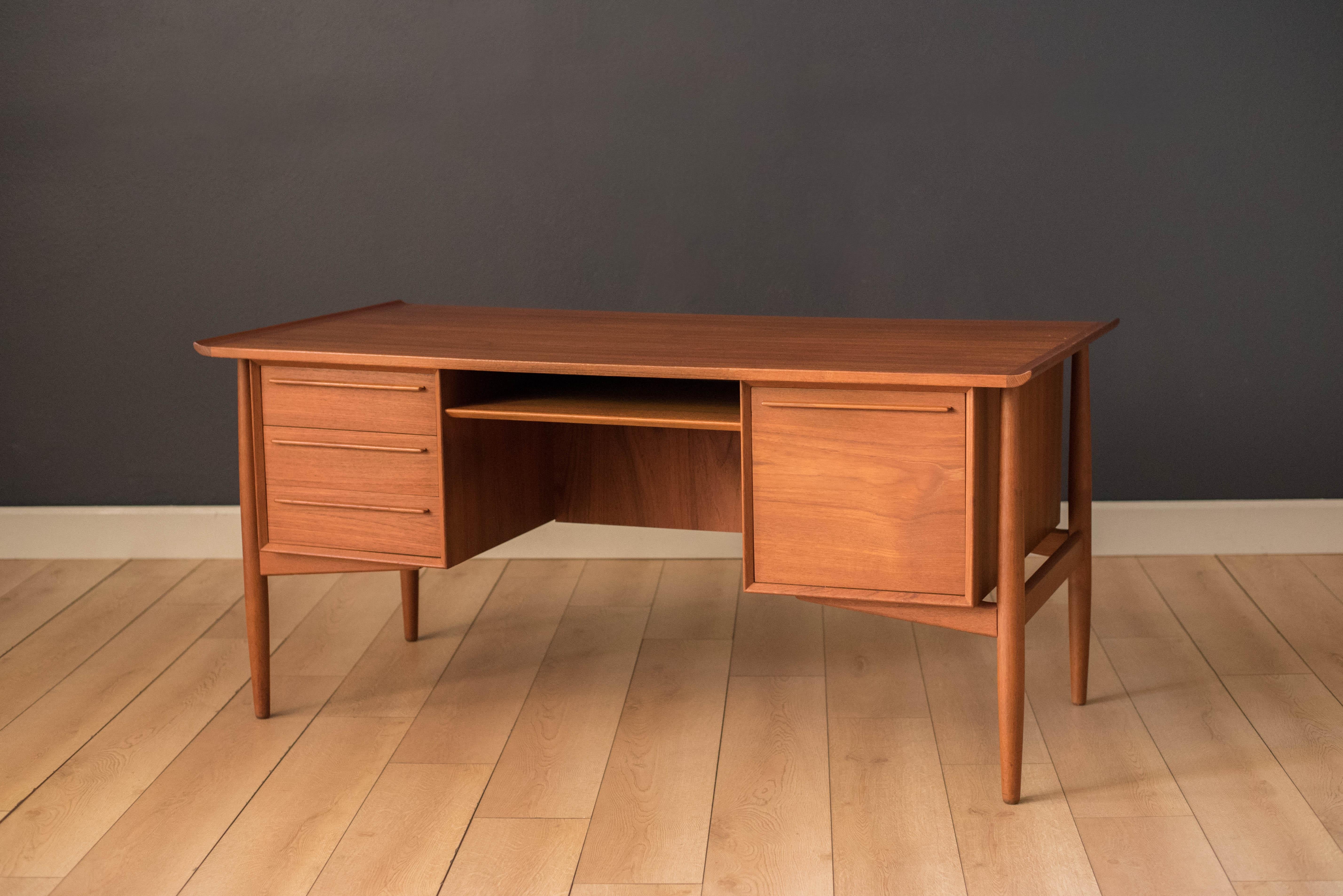 Midcentury executive desk in teak manufactured by H.P. Hansen, Denmark, circa 1960s. This piece is equipped with four dovetailed storage drawers including a filing cabinet. Features a raised sculpted top and floating external legs. This versatile
