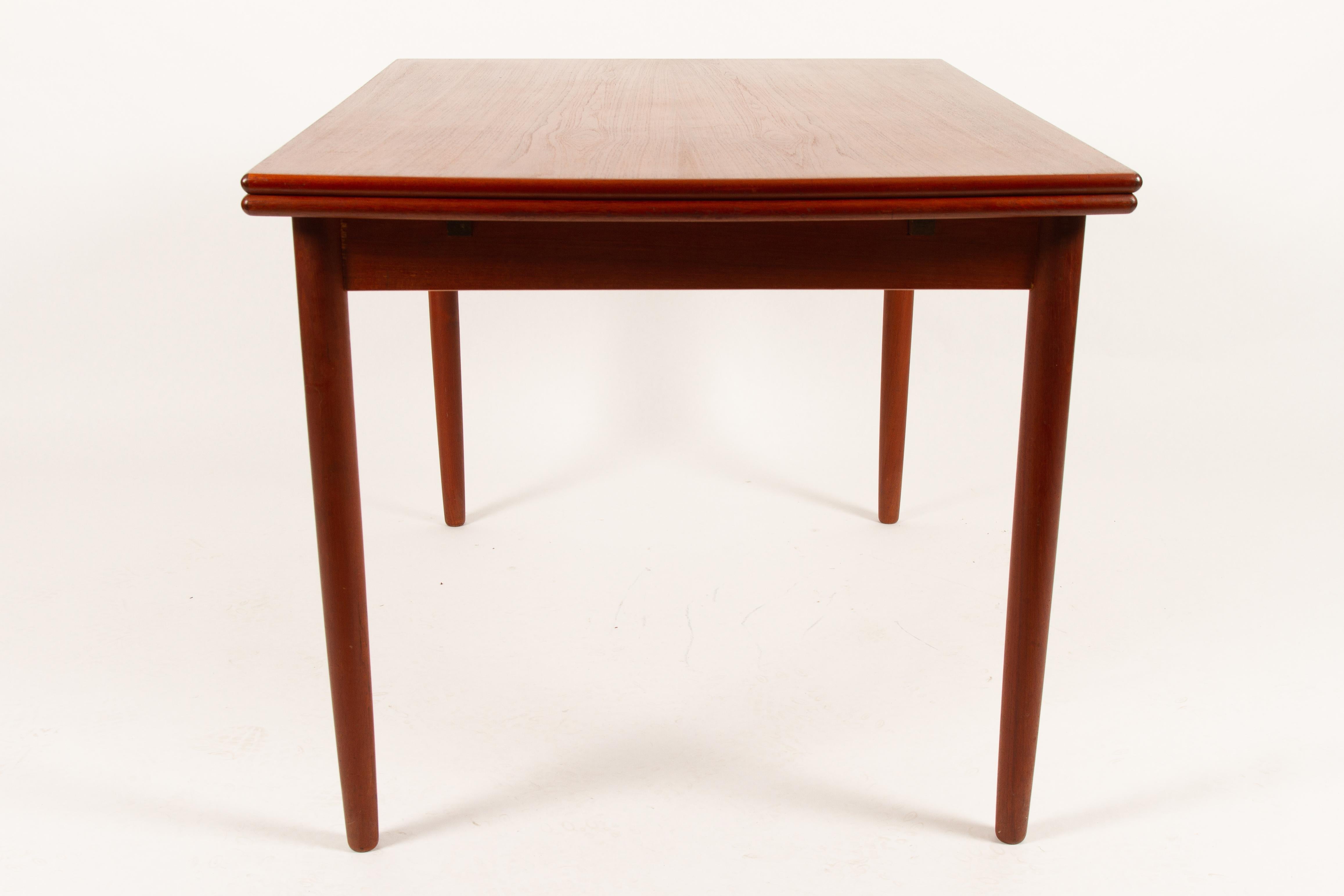 Classic Danish extendable dining table with draw out leaves. Beautiful teak veneer with edges in solid teak. Standing on round tapered legs. Light and elegant, and easy for one person to pullout / pull-out. Very good vintage condition. All surfaces