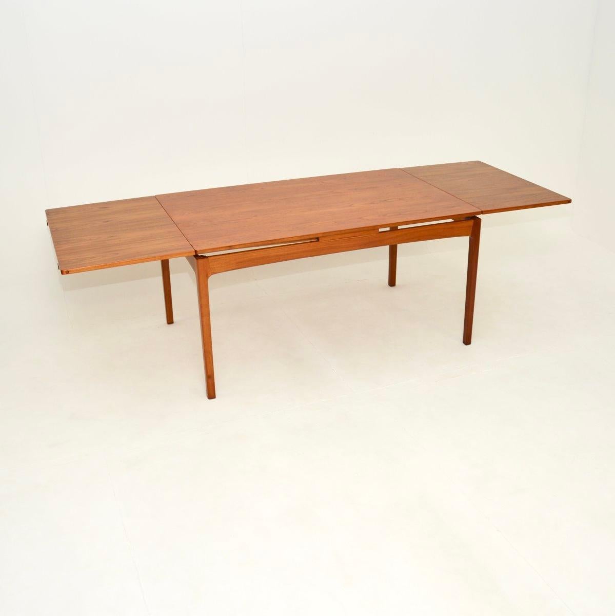 Superbe table de salle à manger danoise en teck, datant des années 1960.

Il s'agit d'un produit de la plus haute qualité, au design extrêmement épuré et élégant. Il est fabriqué en teck massif et plaqué, avec deux rallonges qui se glissent en