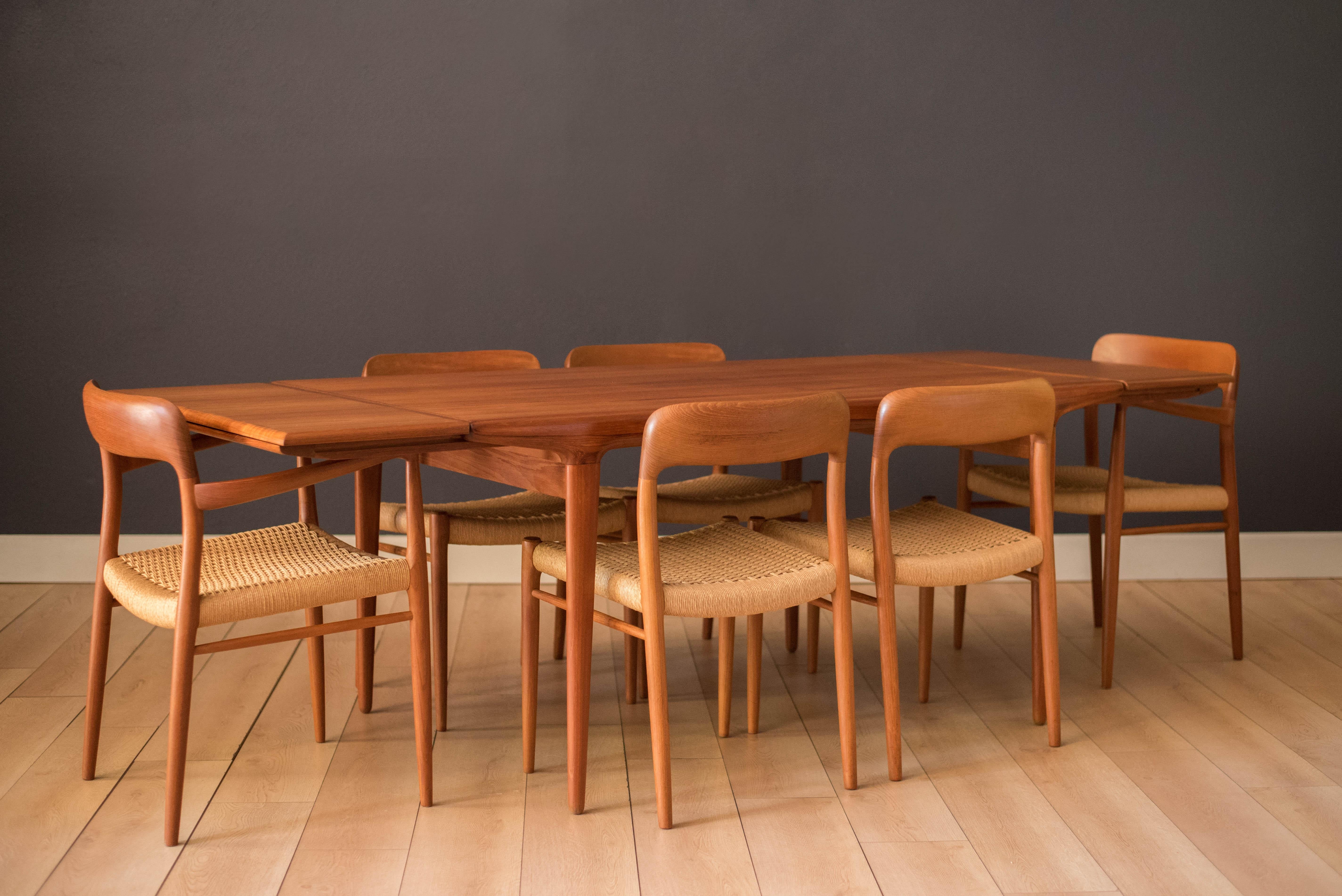 Midcentury expandable dining table in teak designed by Niels O. Moller for J.L. Mobelfabrik, Denmark. This versatile piece includes two pocket leaf extensions that cleverly store underneath the table. Features smooth rounded edges and slightly