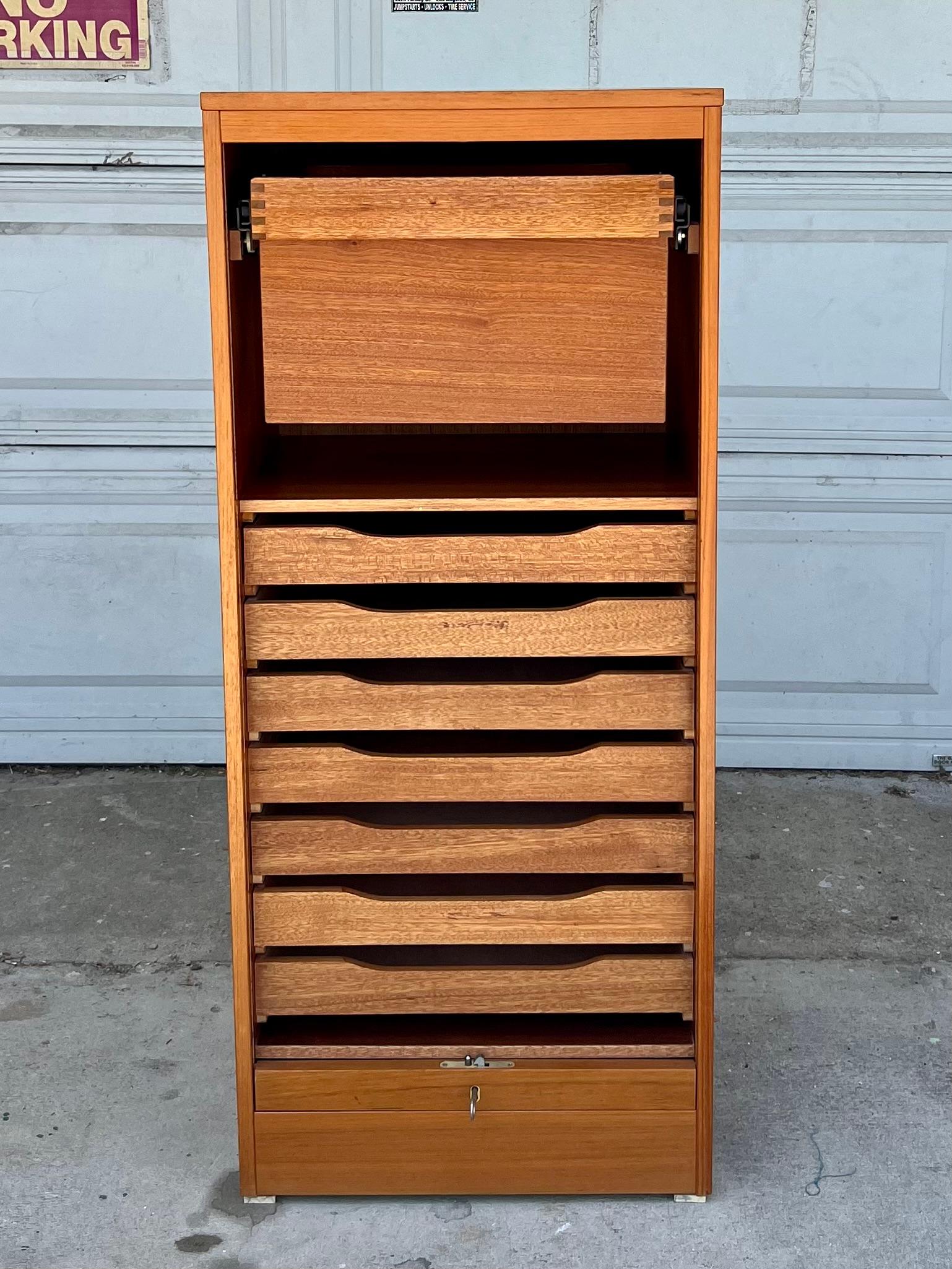 This Mid Century Teak Cabinet offers plenty of space for organization behind its smooth gliding tambour door. Rich teak grain completes this piece making it a stylish addition to any office or room. The cabinet has been thoroughly cleaned and