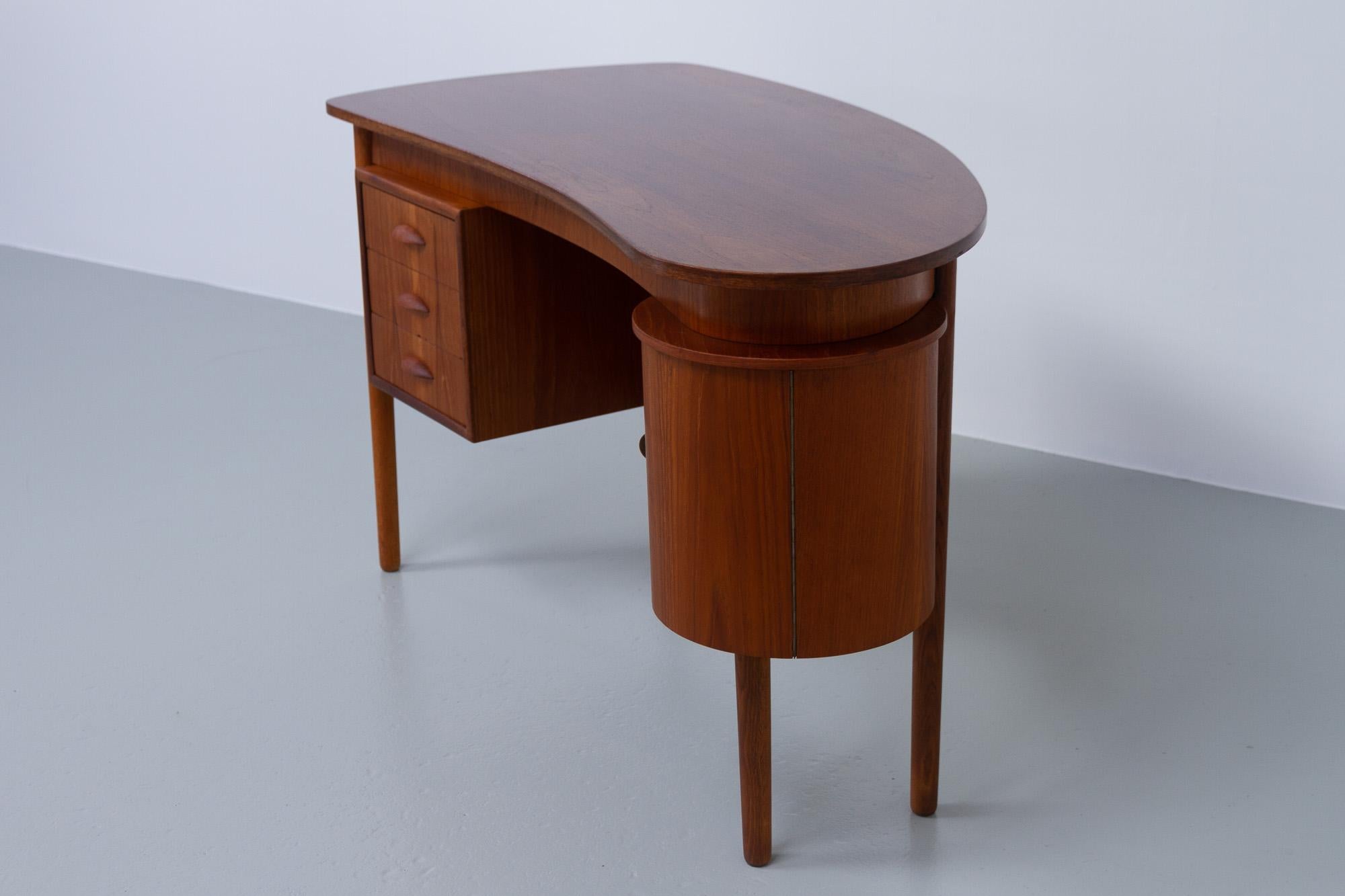 Vintage Danish teak kidney desk, 1950s.

Danish Mid-Century Modern freestanding organically shaped writing desk made in Denmark in the 1950s. Kidney shaped table top in teak veneer. Drawer section with three drawers with sculpted pulls in solid