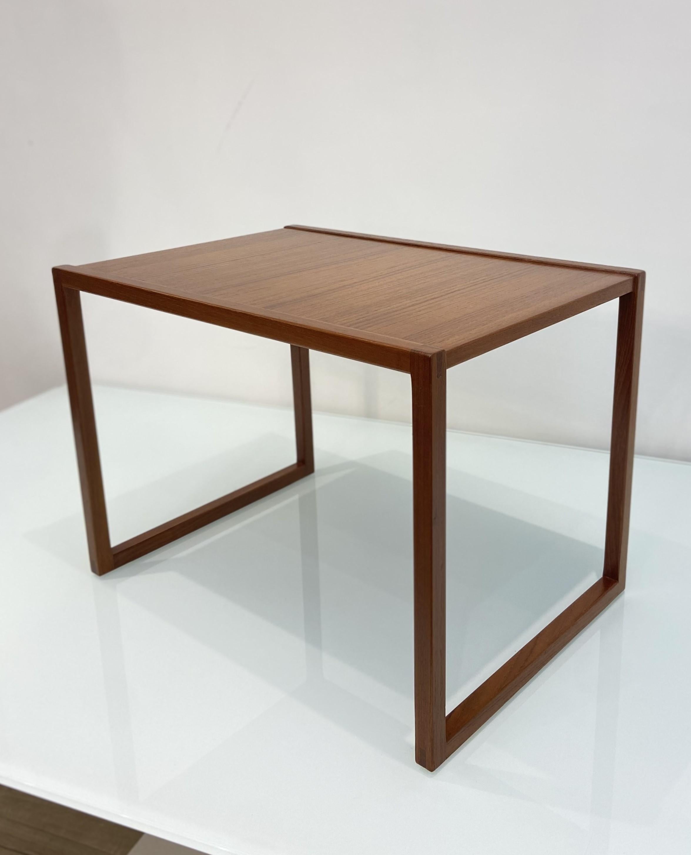 A set of three Danish Mid-Century nesting teak wood occasional tables designed by Kai Kristiansen and manufactured by Vildbjerg Mobelfabrik. 

With three different sizes, each featuring dove tail detailing on the corners, they can be used for
