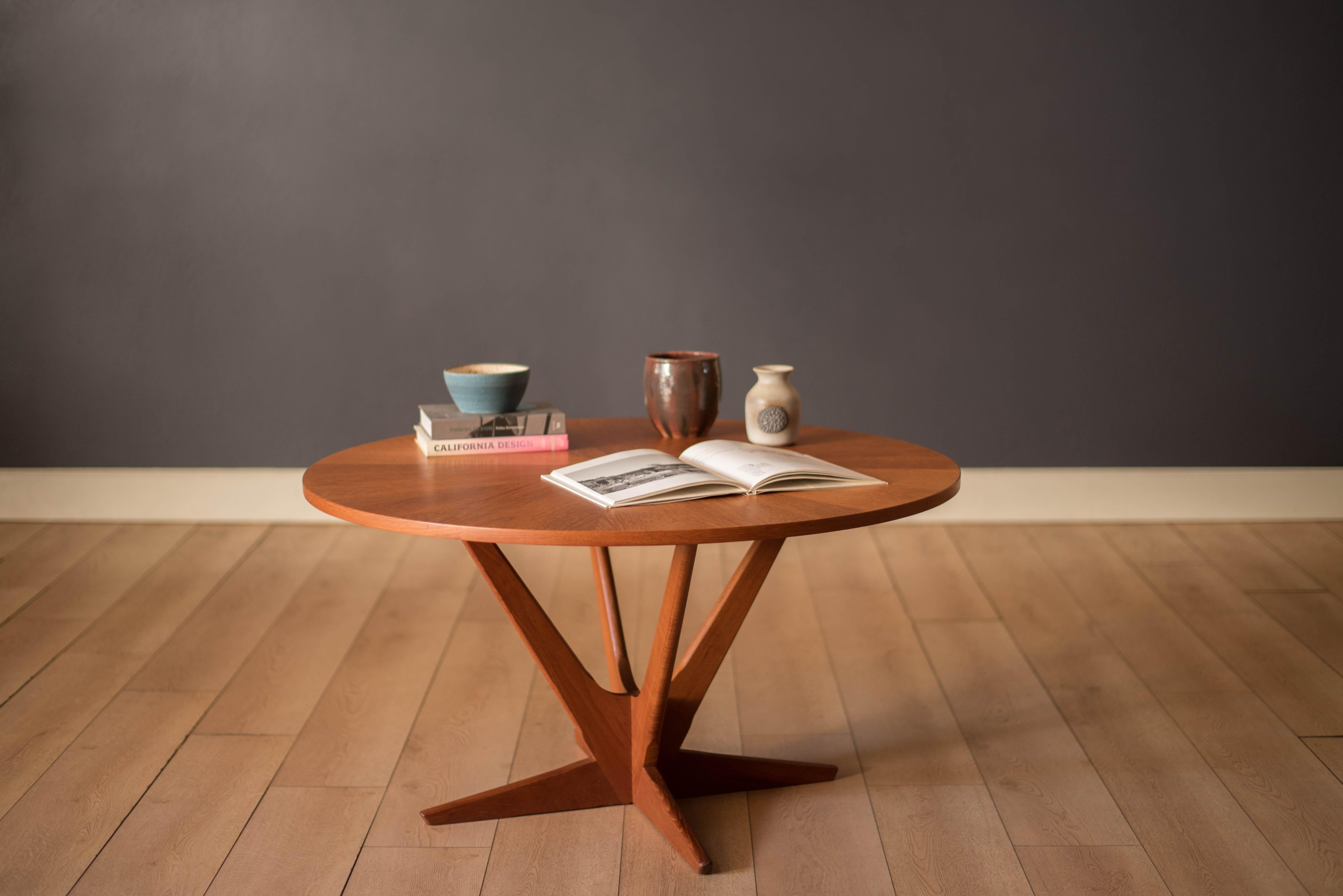 Mid Century Modern round coffee occasional table by Soren Georg Jensen for Kubus, Denmark. The top features a stunning radial teak veneer pattern supported by a unique sculptural atomic base. Perfect to use as a center sectional table or an entry
