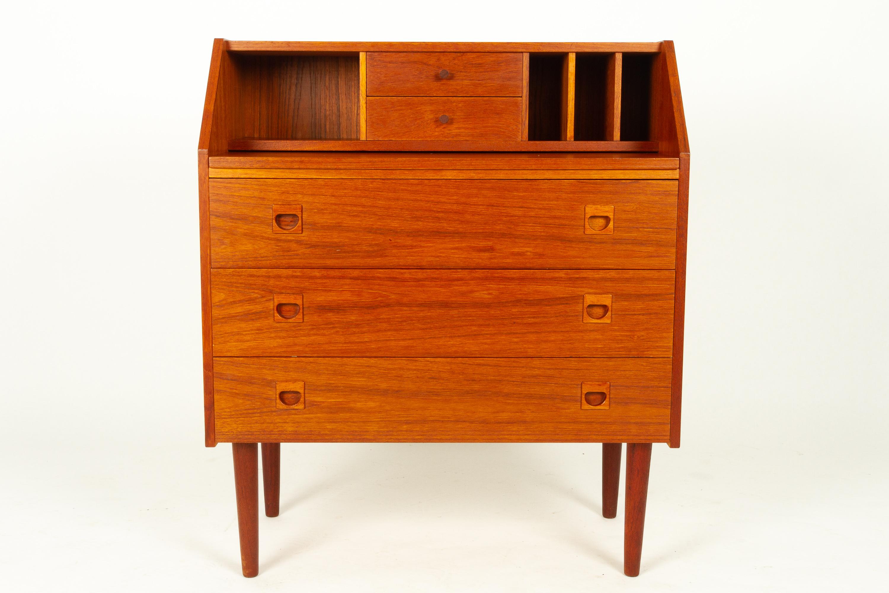 Vintage Danish teak secretaire, 1960s.
Beautiful midcentury modern teak secretary with draw out tabletop. Elegant round tapered legs. Three large drawers with sculpted grips in solid teak. Two small drawers with small round gribs in solid teak. One