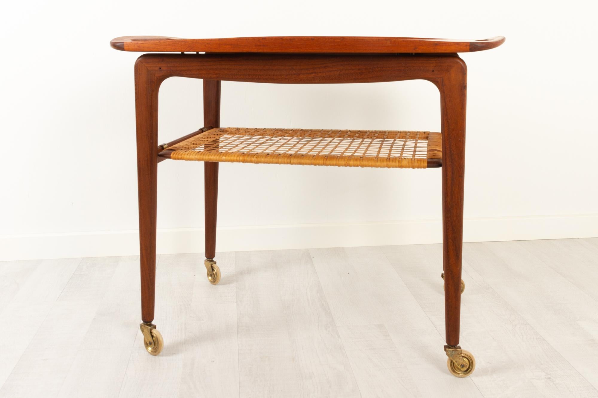 Vintage Danish teak serving trolley by Johannes Andersen, 1960s
Danish modern serving cart in teak and cane attributed to Johannes Andersen for CFC Møbler. Removable teak tray with handles in solid teak. Underlying shelf with cane, also removable.