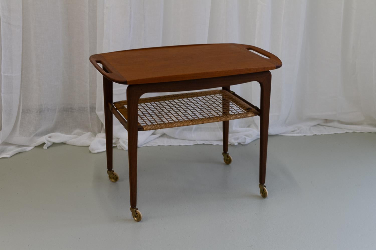 Vintage Danish teak serving trolley by Johannes Andersen, 1960s.

Danish modern serving cart in teak and cane attributed to Johannes Andersen for CFC Møbler, Denmark. Removable teak tray with handles in solid teak that can be used as a serving tray.