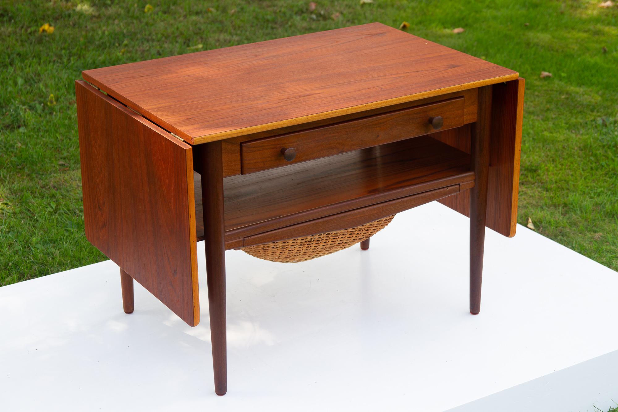 Vintage Danish teak sewing table, 1960s.
Elegant and classic Danish modern expanding sewing table with drawer and basket. This table features two drop down leaves that allows the top to expand to a length of 149.5 cm. One large drawer with several
