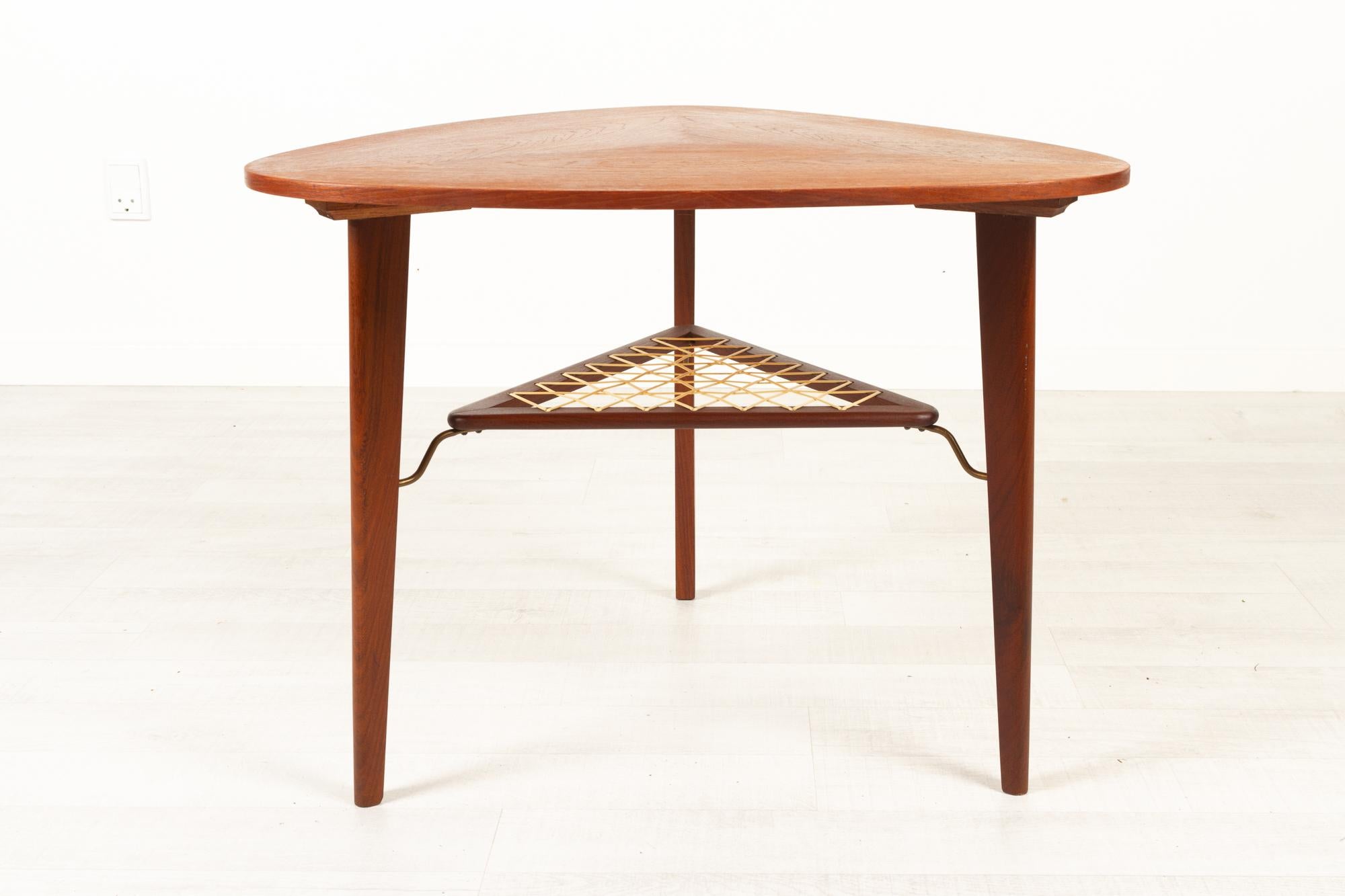 Vintage Danish teak side table 1960s
Triangular Danish Mid-Century Modern side or coffee table in teak with shelf attributed to Georg Jensen for Kubus Møbler. Elegant design with three round tapered legs. Triangular table top with rounded corners