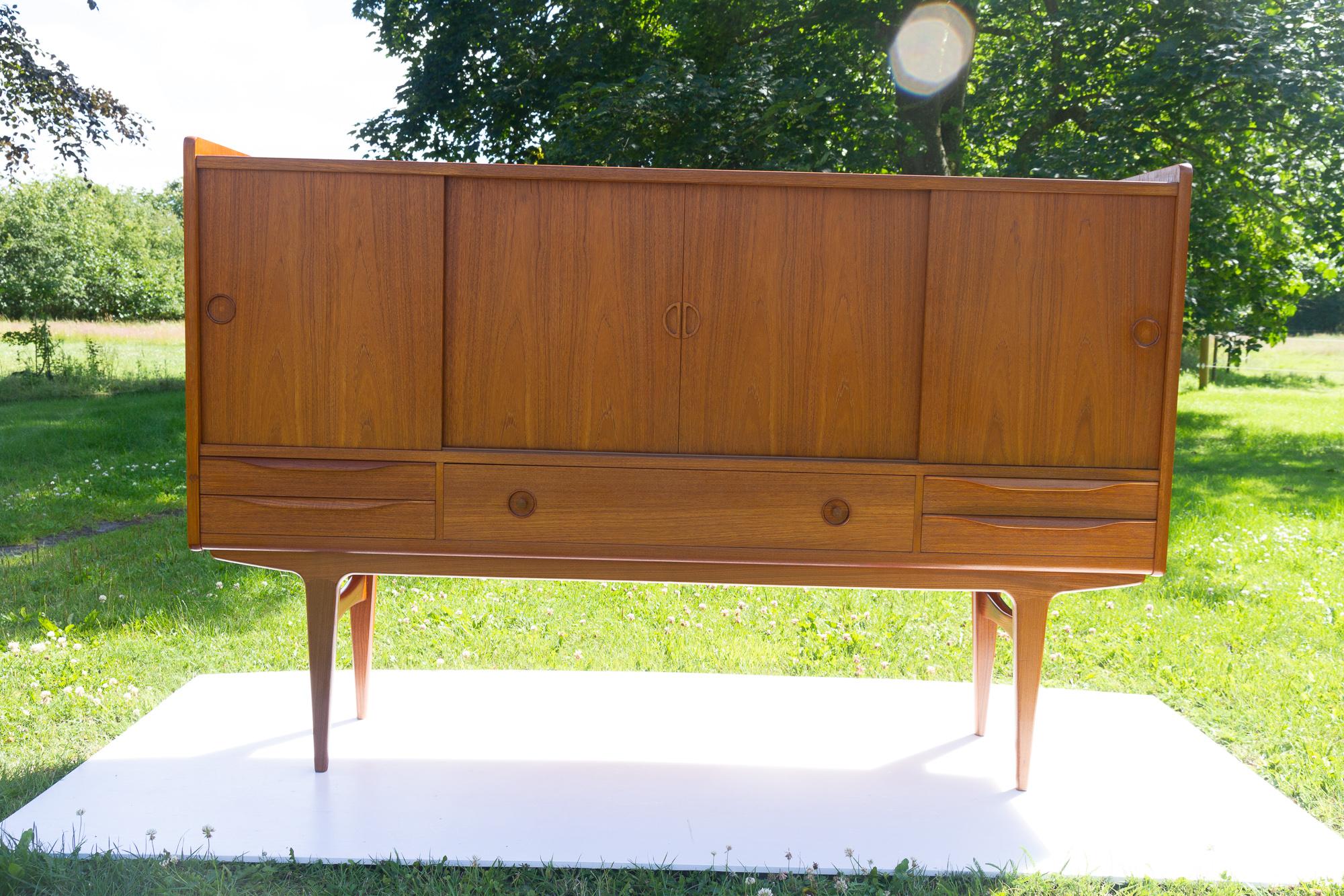 Vintage Danish teak sideboard by Johannes Andersen, 1960s
Danish modern highboard attributed to Danish architect Johannes Andersen and manufactured by Uldum Møbelfabrik, Denmark.
Behind four sliding doors are two compartments with height