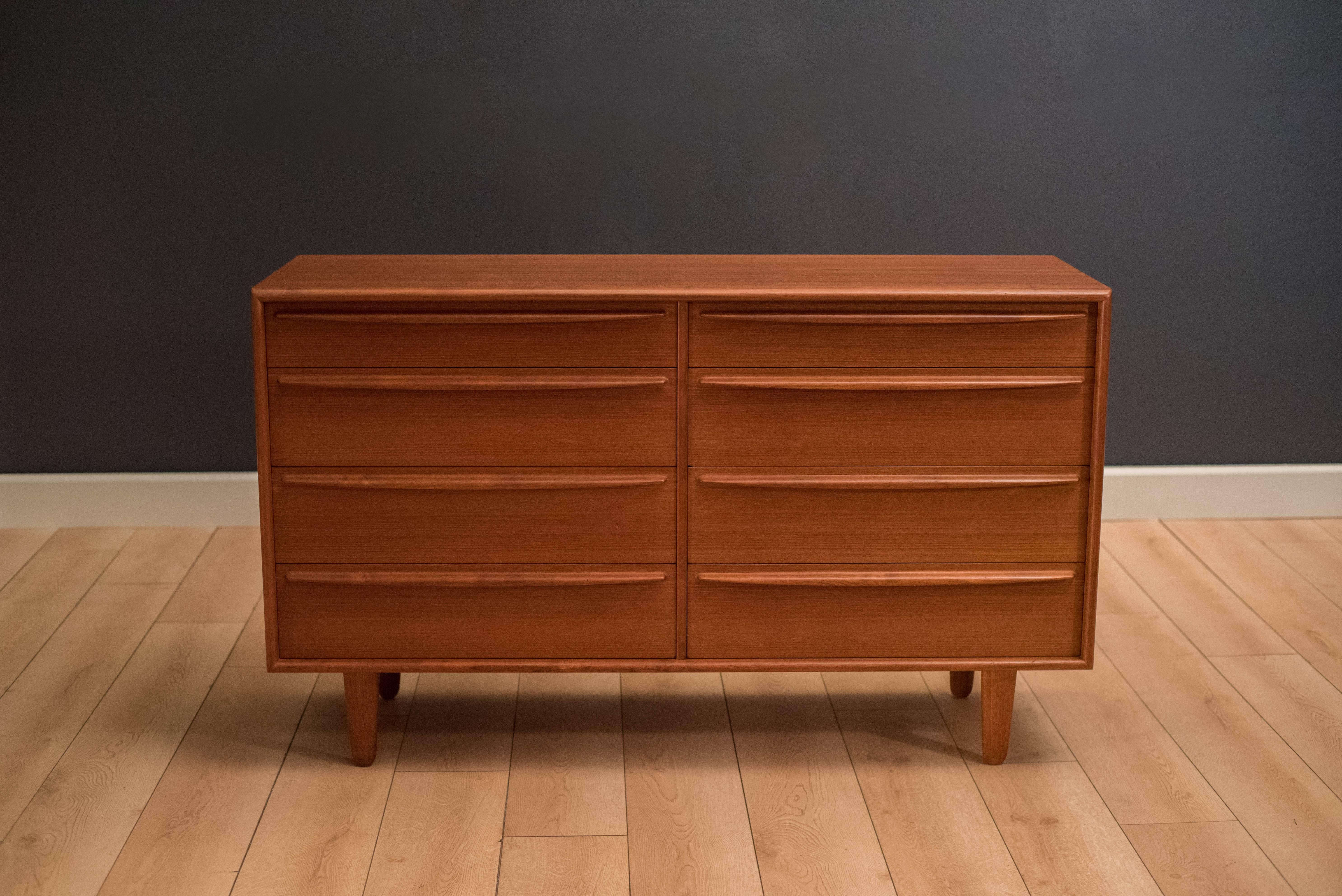 Mid-Century Modern dresser designed by Svend Madsen in teak. This piece features sculpted handles and includes eight dovetailed drawers. Matching tall dresser also available in separate listing.