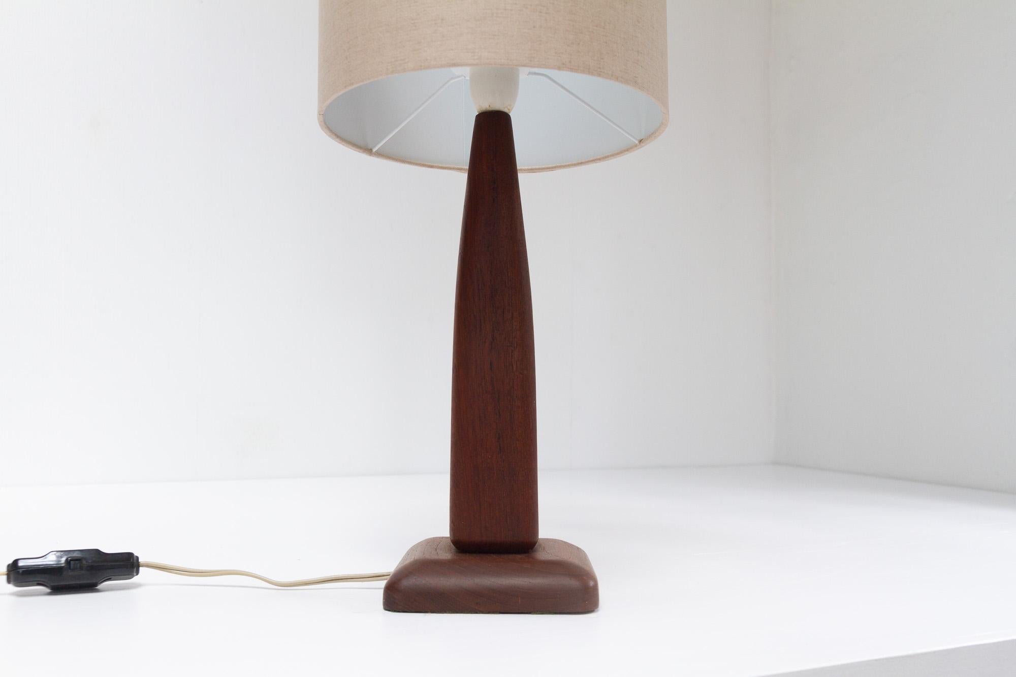 Vintage Danish Teak Table Lamp, 1960s.
Classic and elegant Danish Mid-century modern table lamp in solid teak manufactured in Denmark in the 1960s. Square tapered body on a square base with white socket. Beige textile shade.
Height of teak base: 34