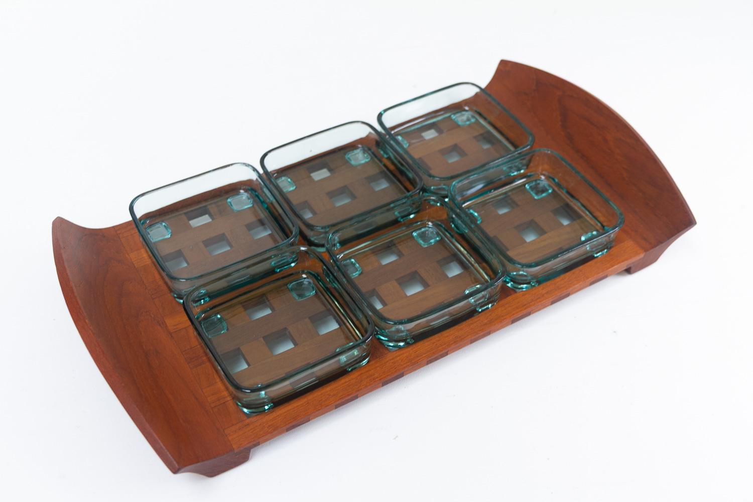Scandinavian Mid-Century Modern teak tray with glass bowls by Jens Harald Quistgaard for IHQ Dansk Designs, 1960s.

Serving tray in solid teak with six green glass dishes. Each dish has feet that fits into the lattice on the tray. Length 46.5 cm.