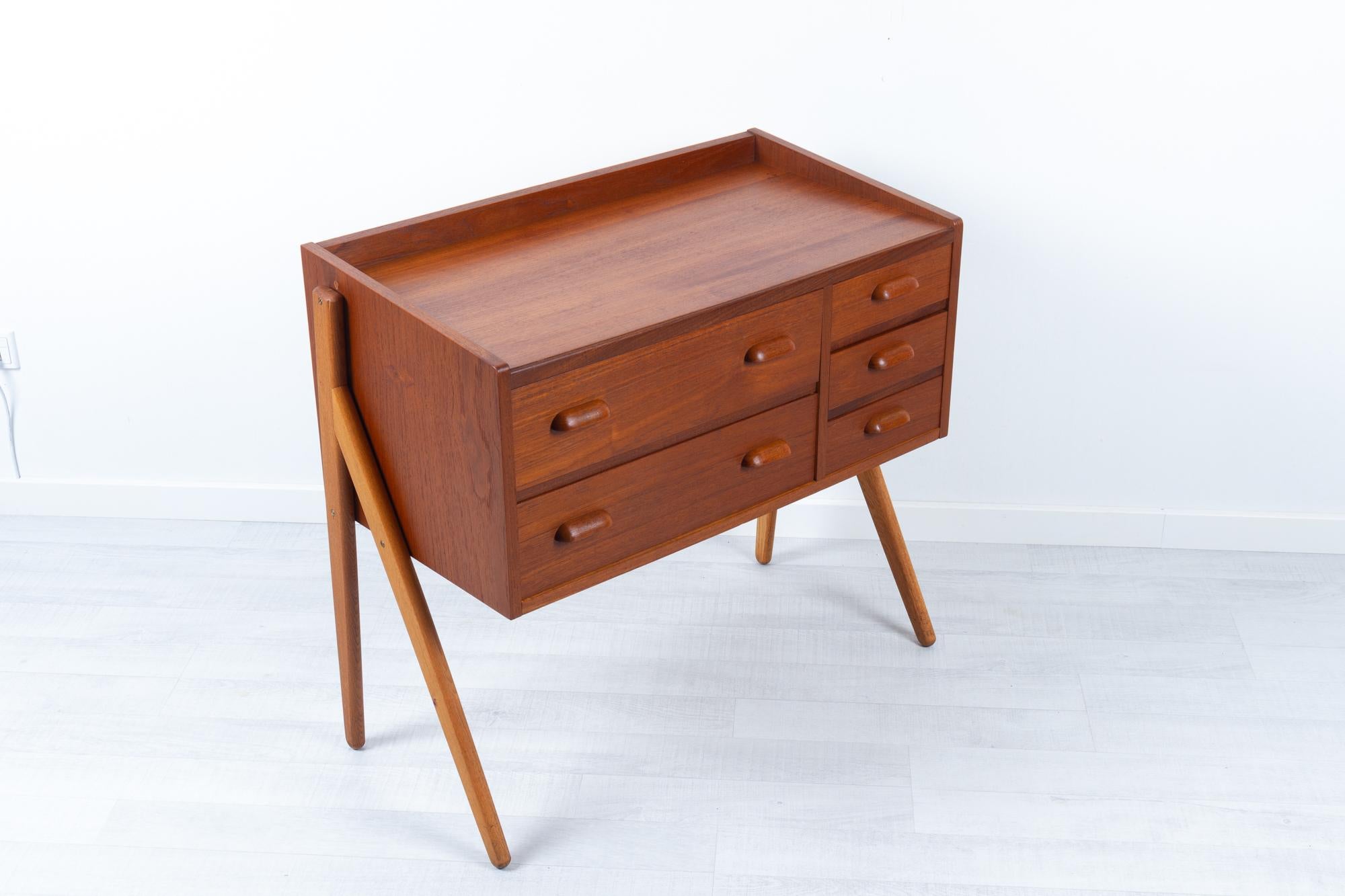 Vintage Danish teak vanity 1960s
Elegant Danish Mid-Century Modern teak dressing table with five drawers. Drawers with sculpted pulls in solid teak. Rounded Y-shaped legs in solid oak.

It originally had a mirror attached, but this has been