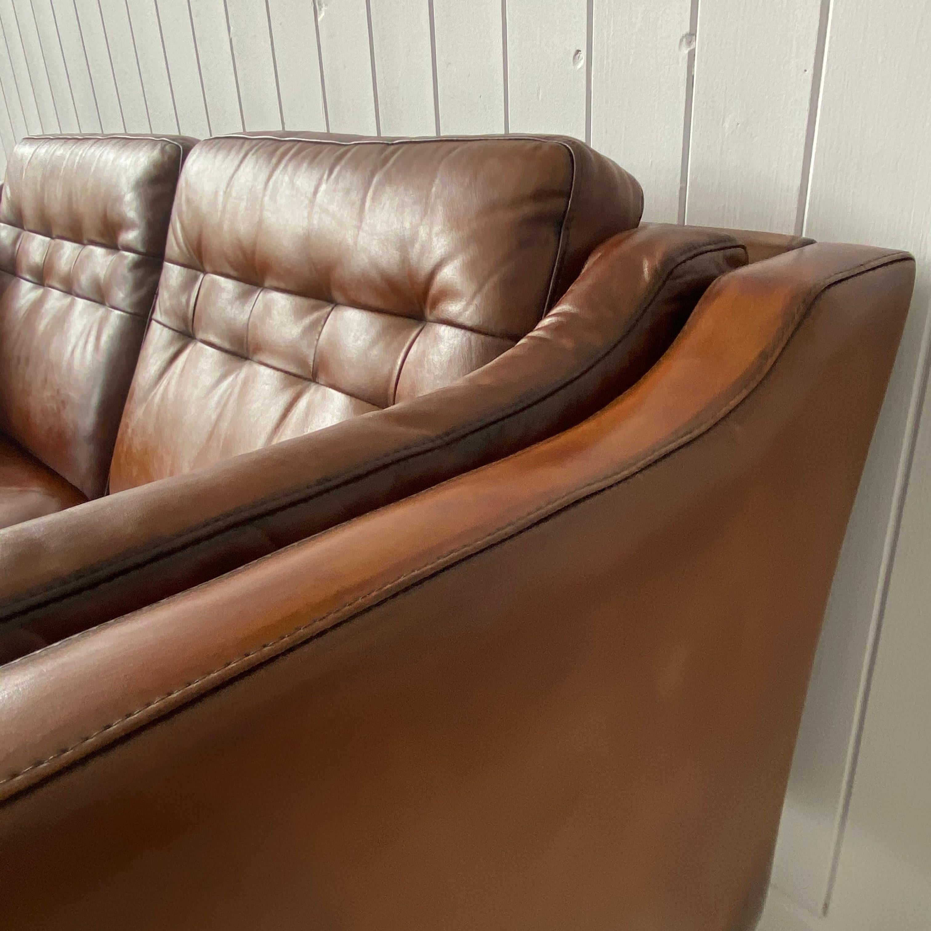 A quality vintage Danish leather two-seat sofa. Cleaned and repolished. Good quality hide and lovely Conker brown color and most importantly its very comfortable.