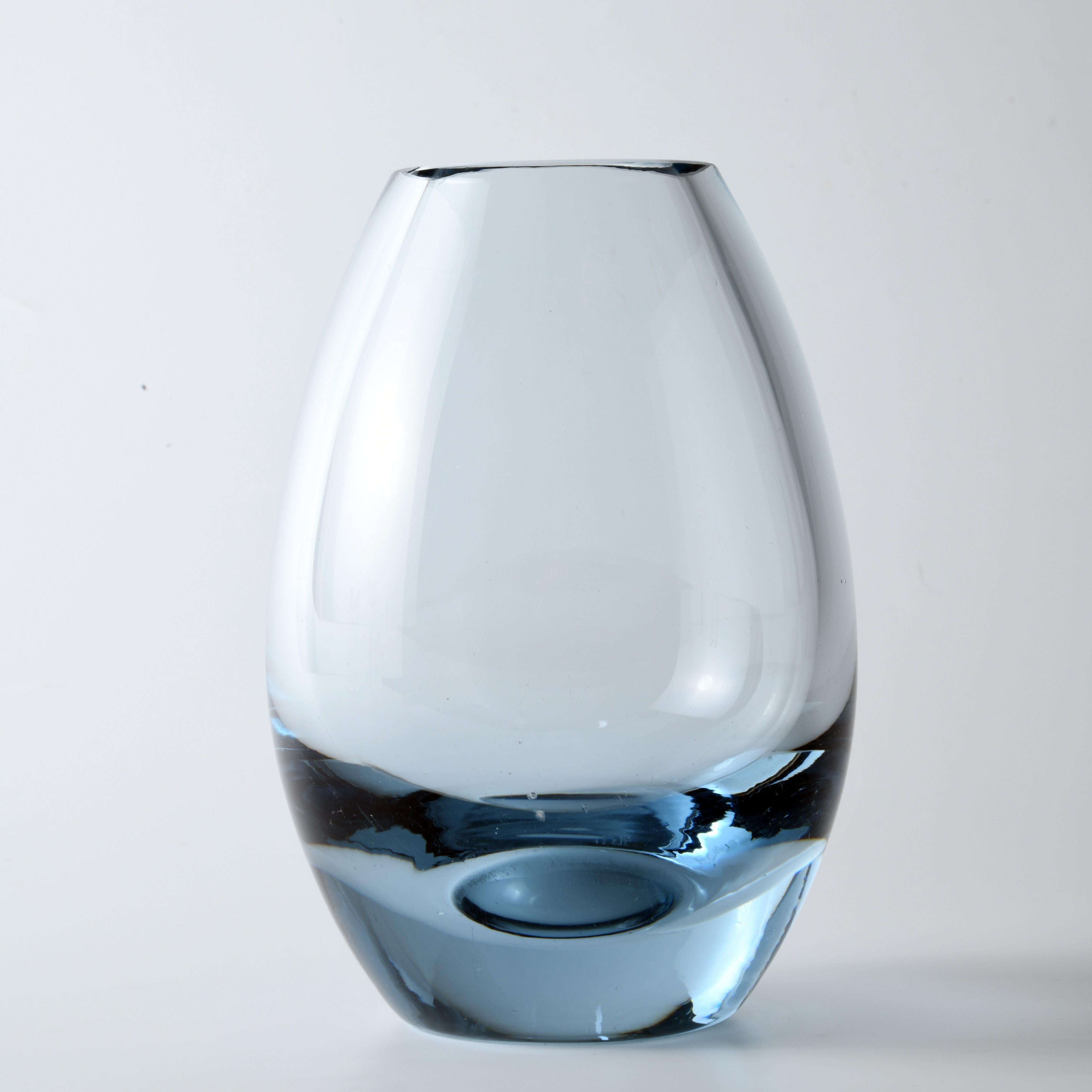 Small glass vase, designed in 1962 by Per Lutken (1916-1998), published by the famous Danish glass company Holmegaard. The bluish tone, the thickness of the glass visible at the top is an integral part of the design of this vase, dated and signed