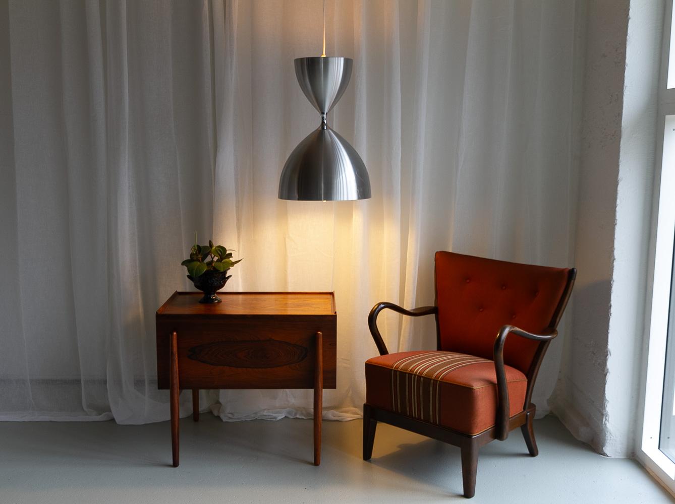 Vintage Danish Vega Pendant by Jo Hammerborg for Fog & Mørup, 1960s.
Iconic Danish modern lighting design by Danish designer Jo Hammerborg for Fog & Mørup, Denmark.

Large hourglass shaped ceiling lamp in brushed aluminium with dual function. Upward