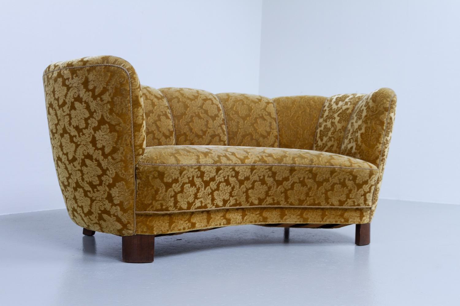 Vintage Danish velvet Art Deco banana sofa, 1940s.

Vintage Art Deco banana-shaped loveseat upholstered in golden mohair velvet with floral motifs made by cabinetmaker in Denmark in the 1940s. Curved two-seater with original spring and velour
