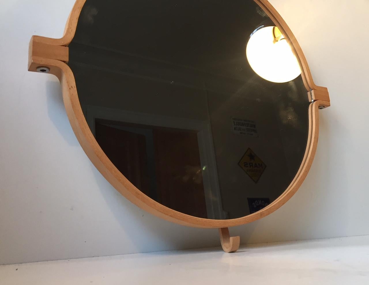 A bend wood wall mirror in beech. Designed and manufactured by Indan in Denmark during the 1980s. This is design number: 009 and it features a practical built in hook to the bottom.