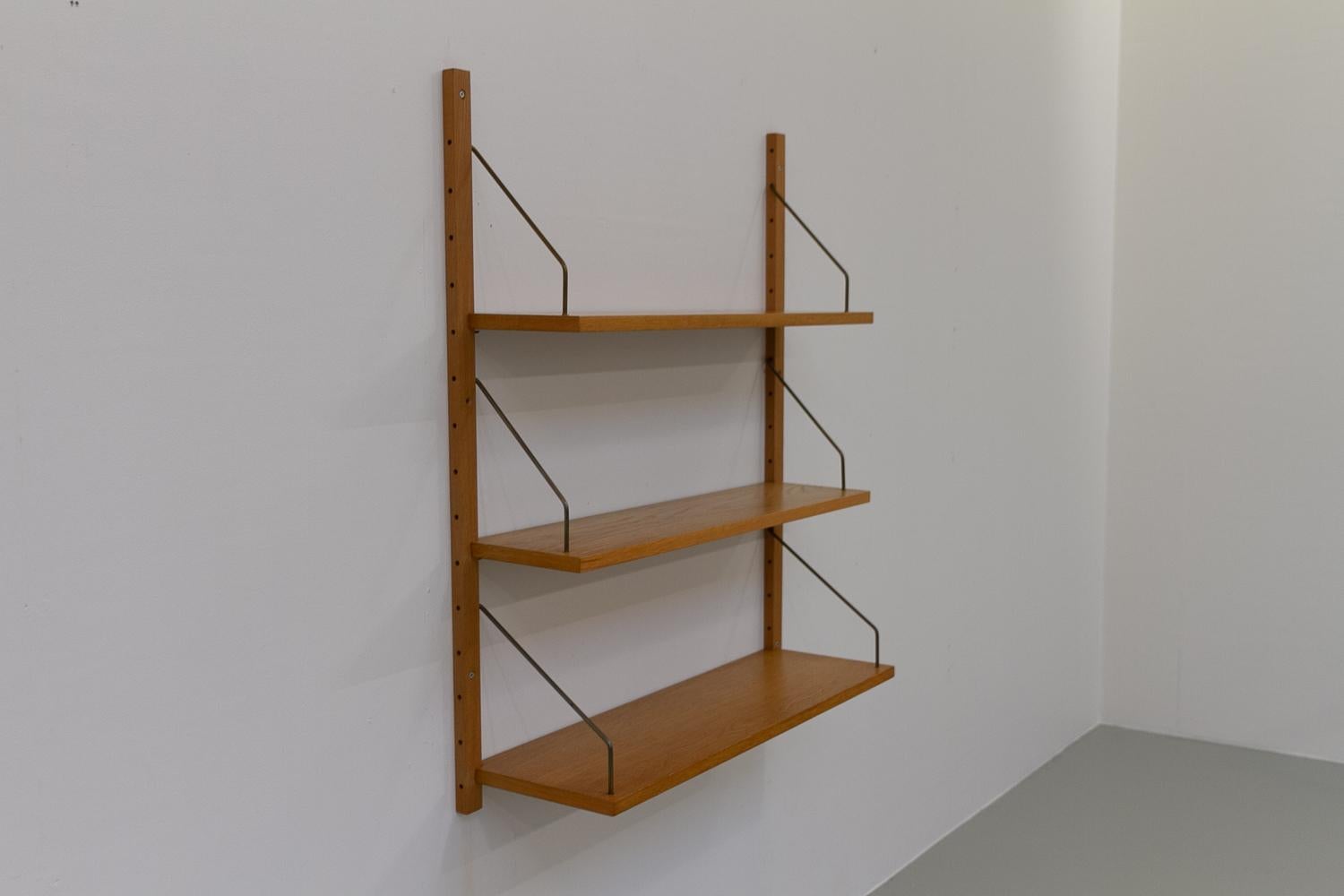 Vintage Danish Wall Mounted Oak Shelving System, 1960s.
Floating Scandinavian Modern 1 bay wall unit in oak with three shelves.
Each shelf is mounted with patinated brass brackets. In the style of Poul Cadovius. 

This set consists of:
2 Uprights in